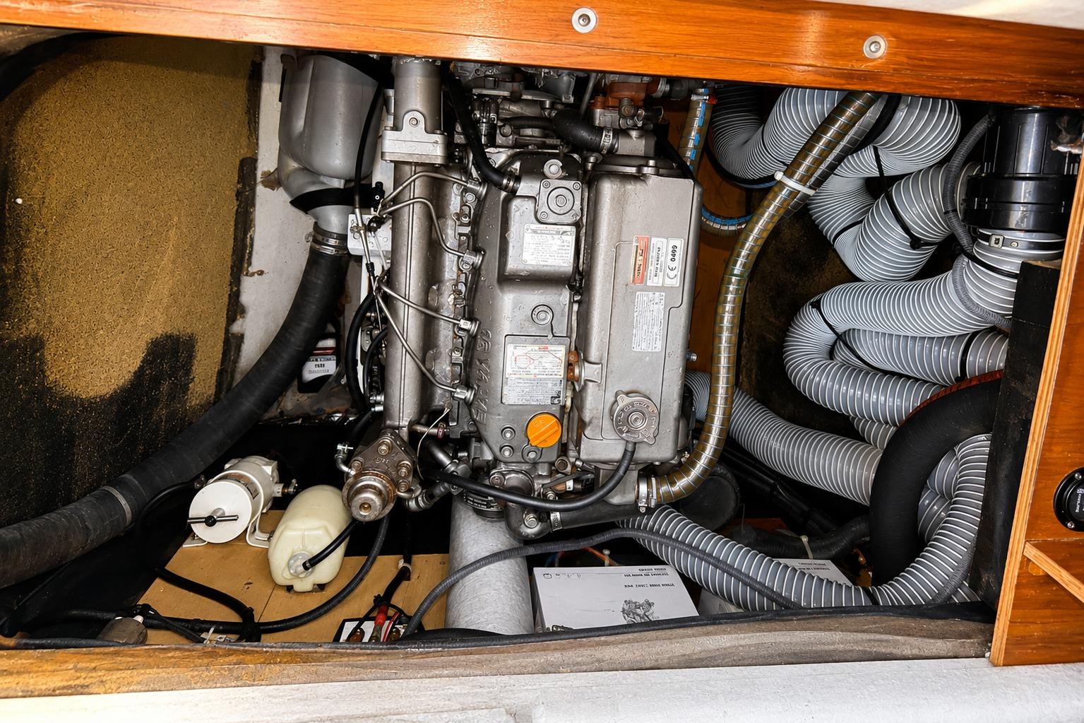 Engine compartment of a 2010 Lagoon 421 yacht, featuring mechanical components and hoses.
