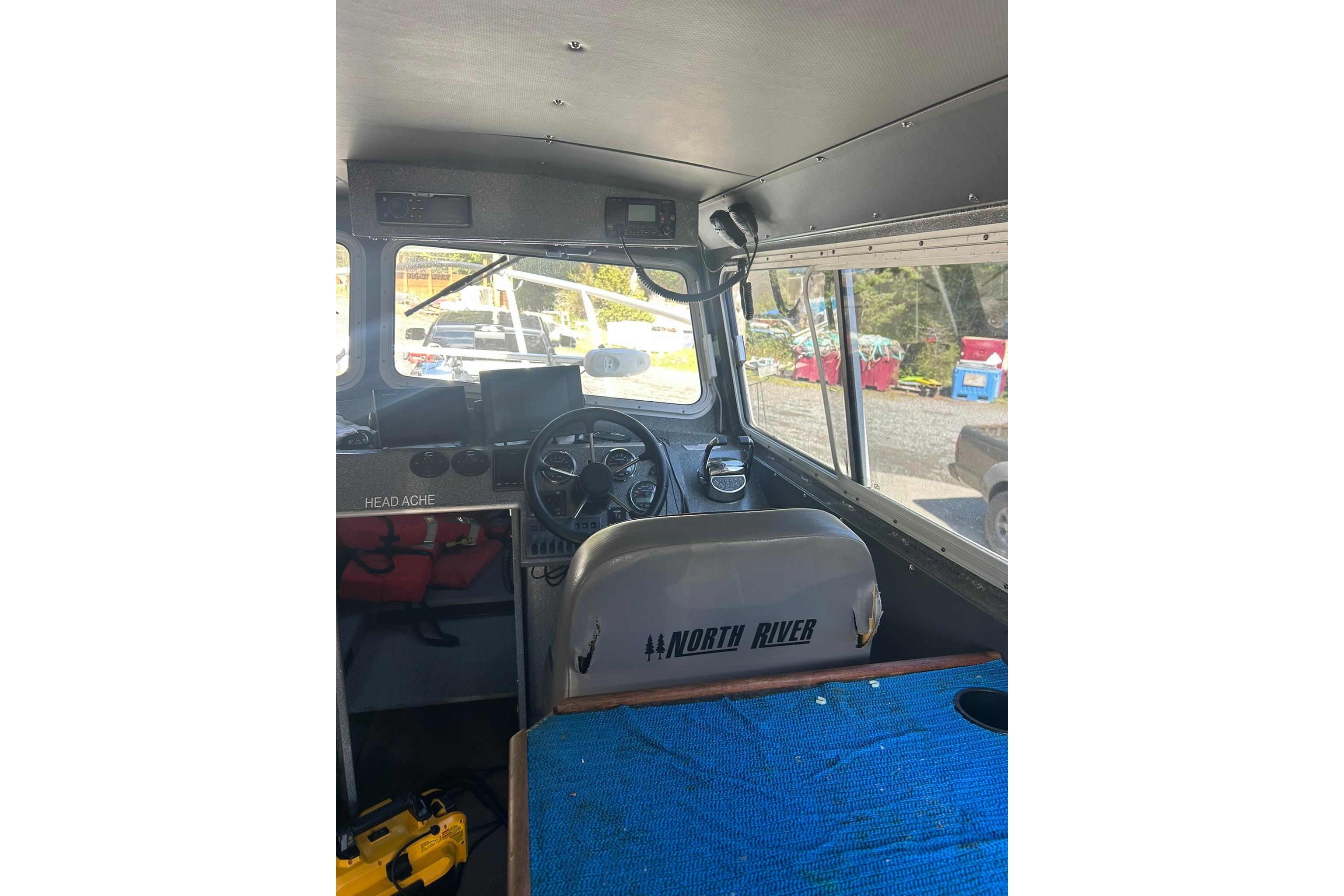 Interior of a 2016 North River 29 Offshore boat, featuring steering wheel and dashboard.