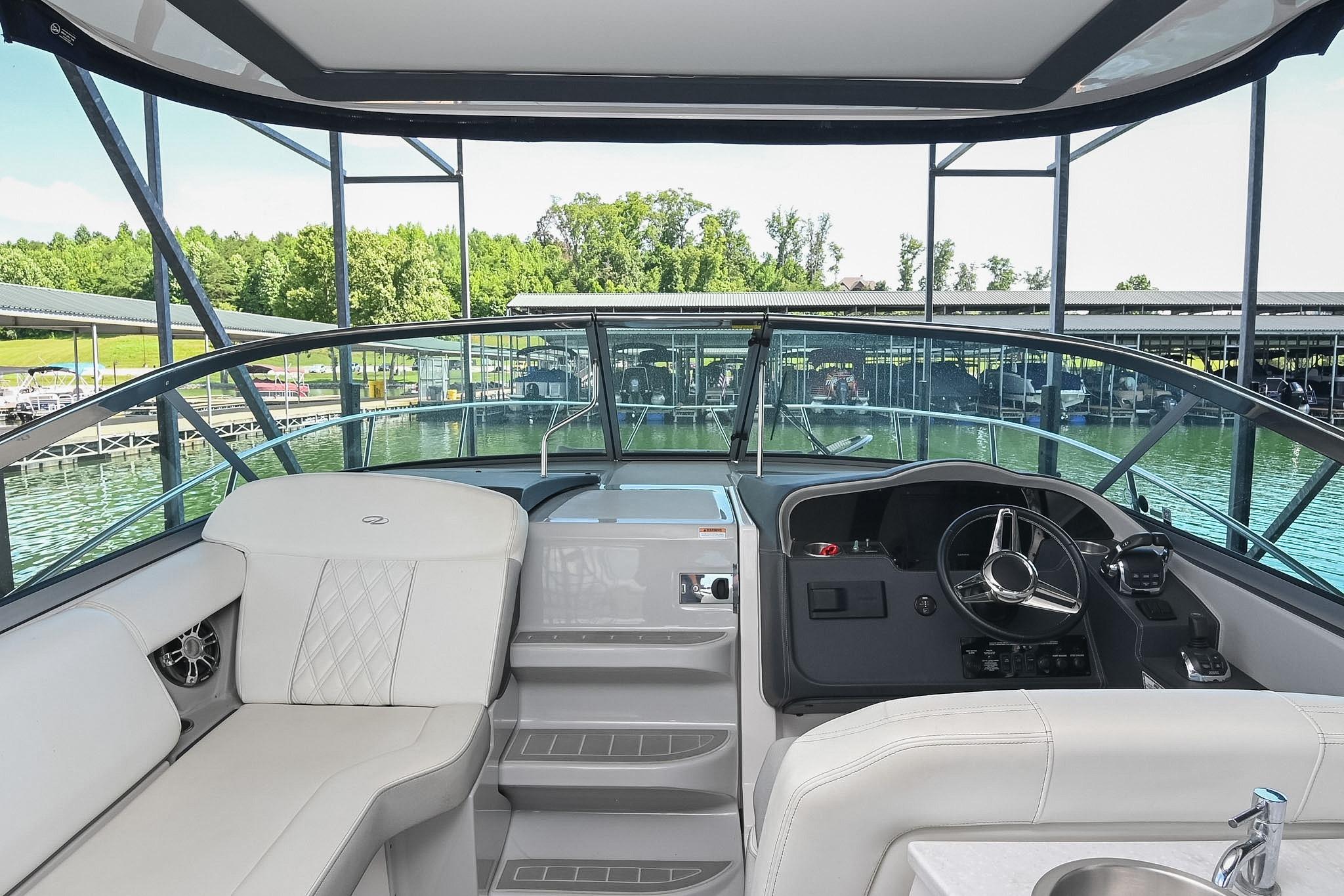 Interior view of 2021 Regal 33 Express boat cockpit with steering wheel and seating.
