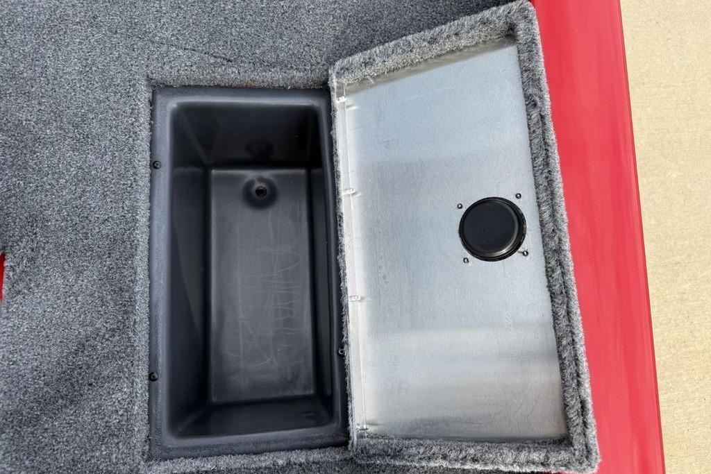 Open storage compartment on 2026 Tracker Pro Team 175 boat, featuring carpeted interior.