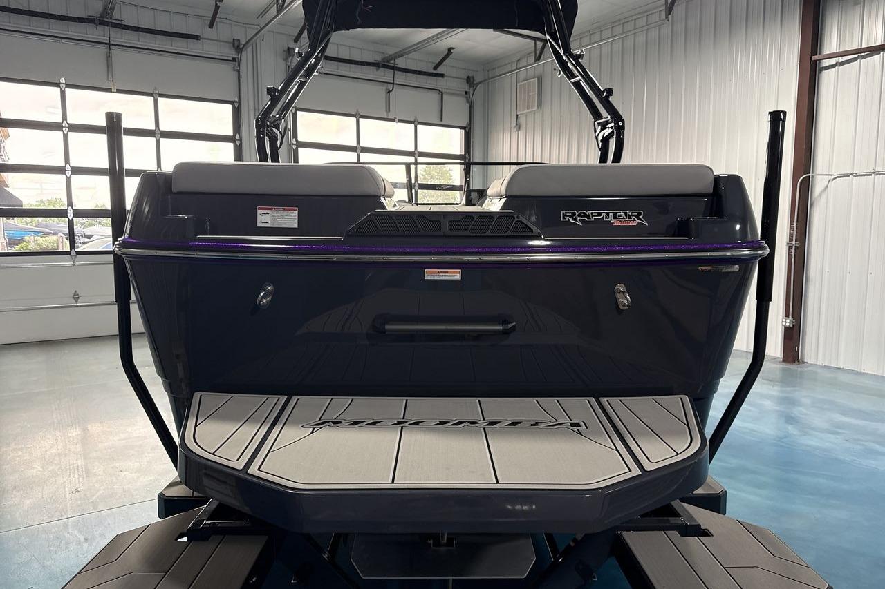 The image shows the rear of a Moomba Craz boat in a warehouse.