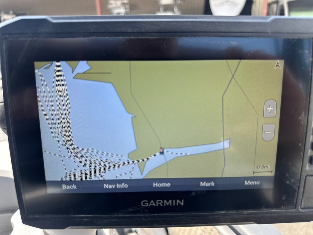 A Garmin navigation device displays a map with route tracking on a boat.