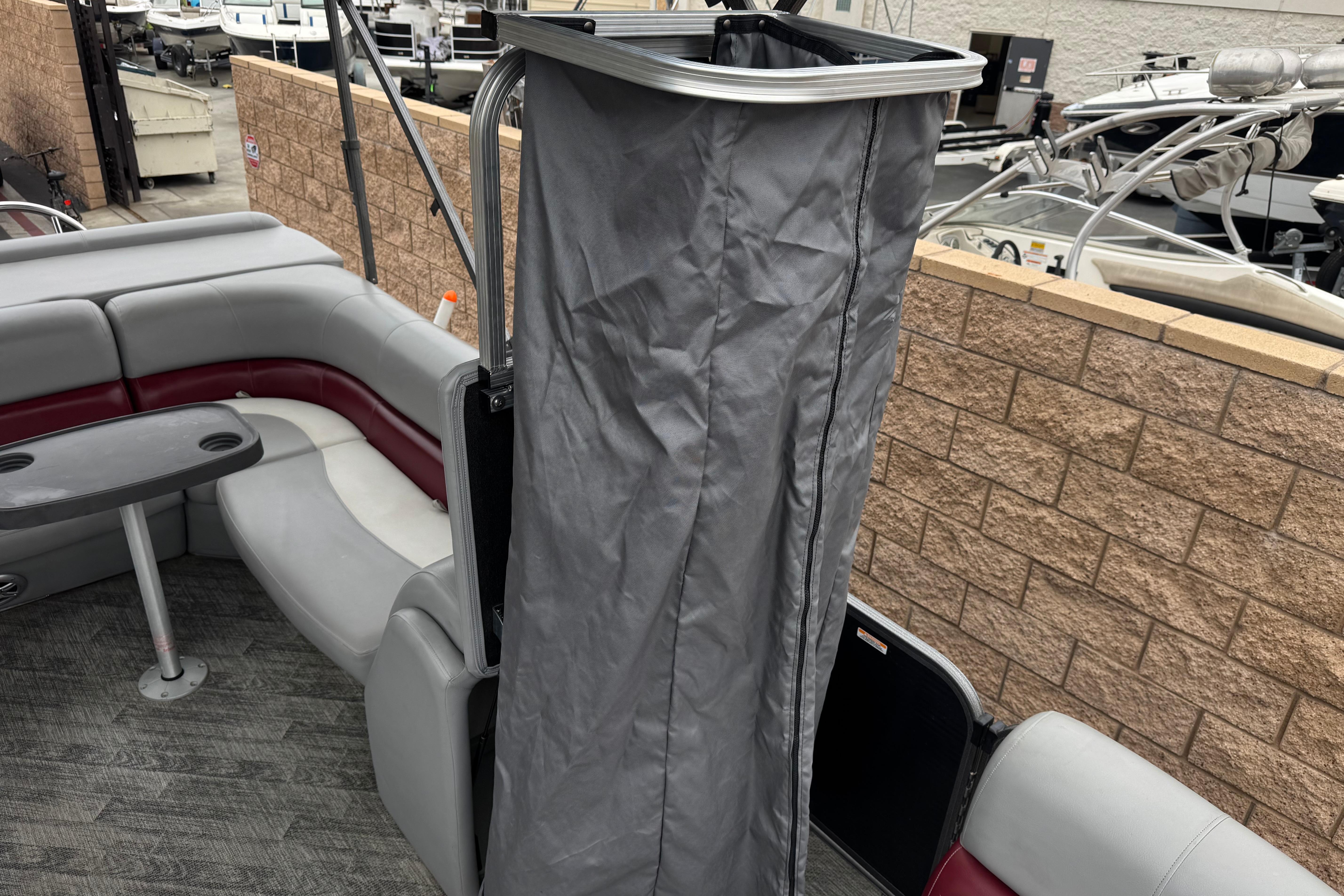2020 Manitou 18 Aurora LE pontoon boat interior with seating and privacy curtain.