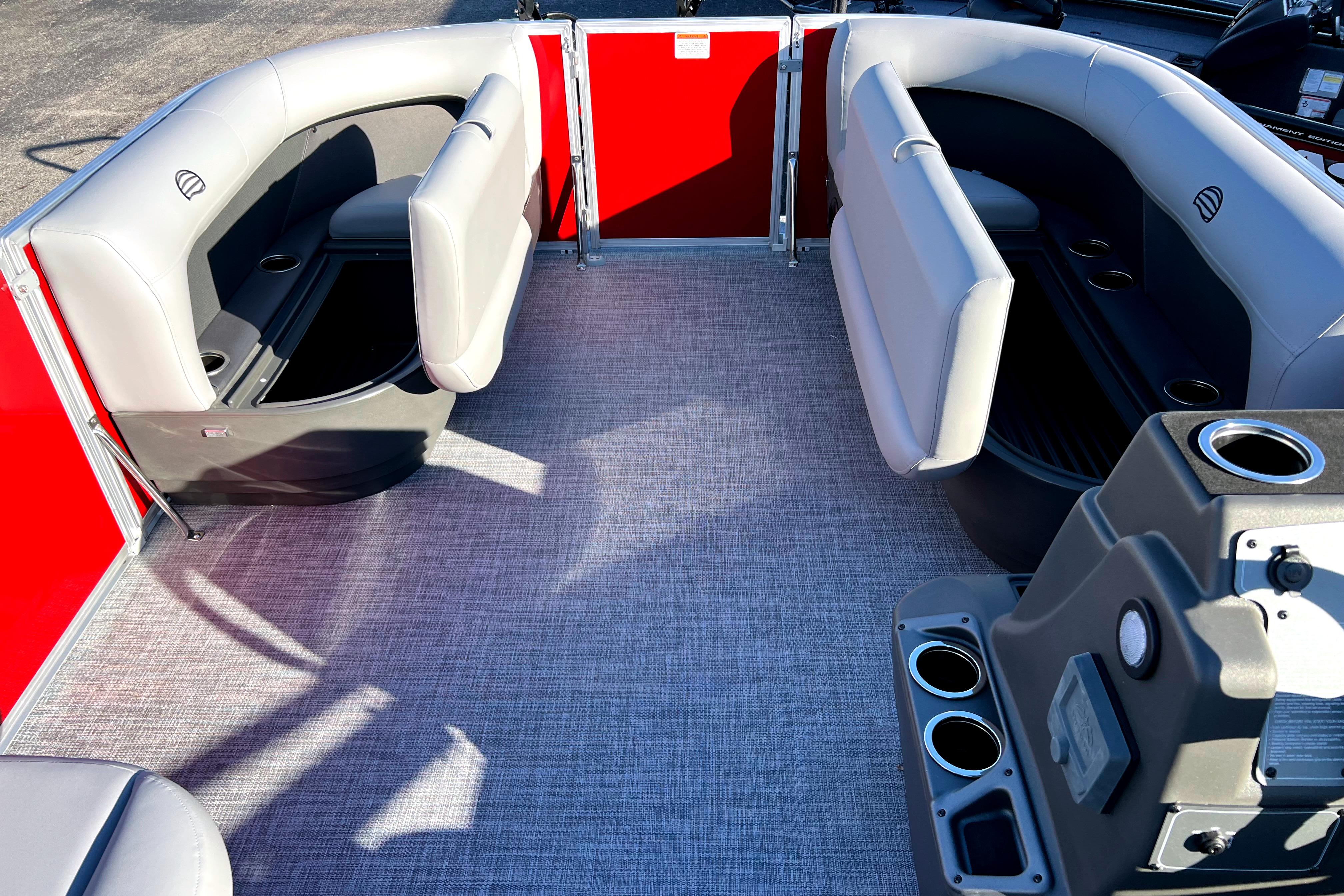 2026 Sun Tracker Party Barge 16 DLX interior with gray seating and red accents.