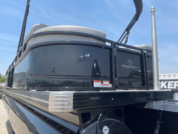 2023 Regency 250 LE3 pontoon boat with sleek black exterior under a clear blue sky.