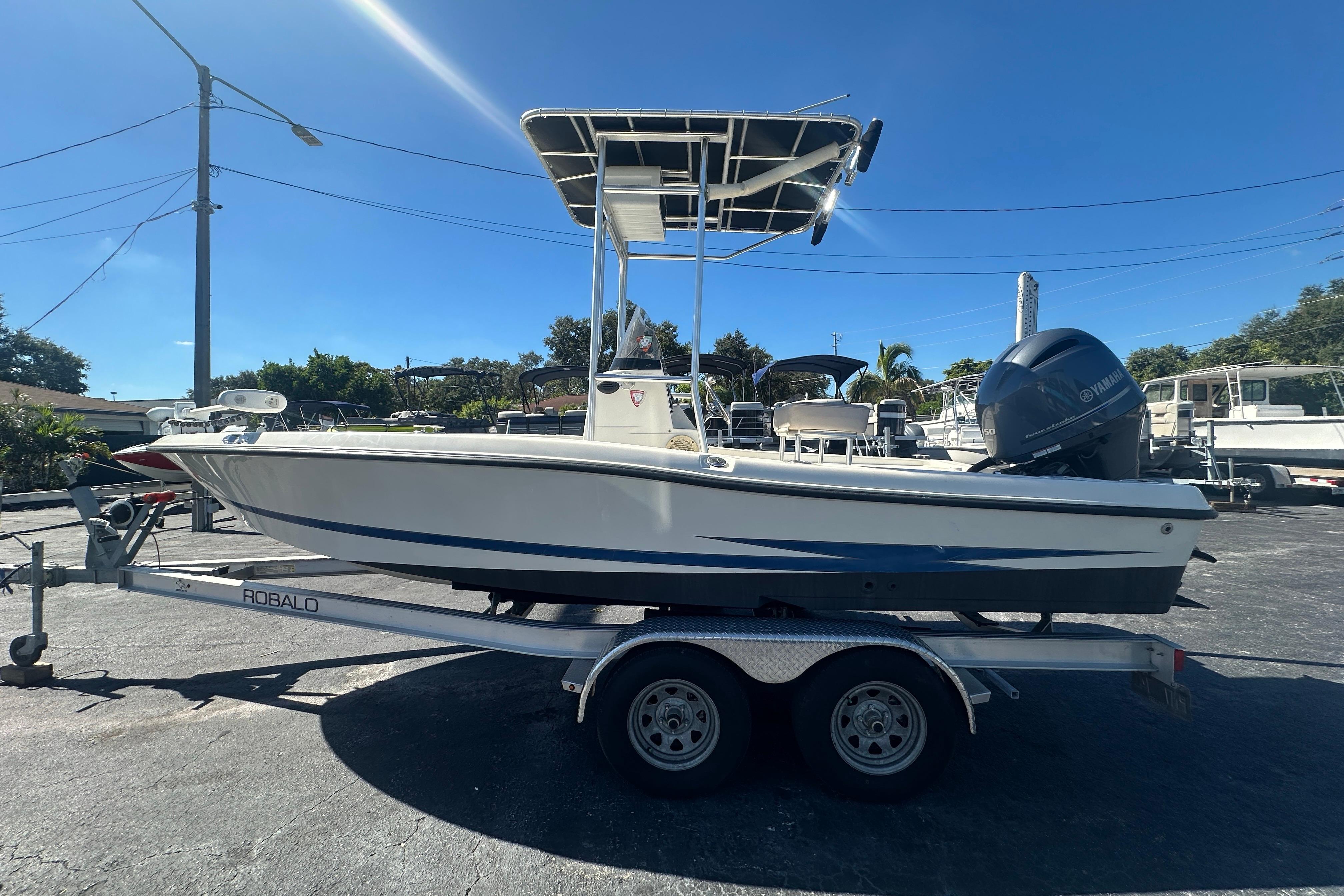 2003 Hydra-Sports 19 Bay Bolt boat on trailer, parked outdoors under clear blue sky.