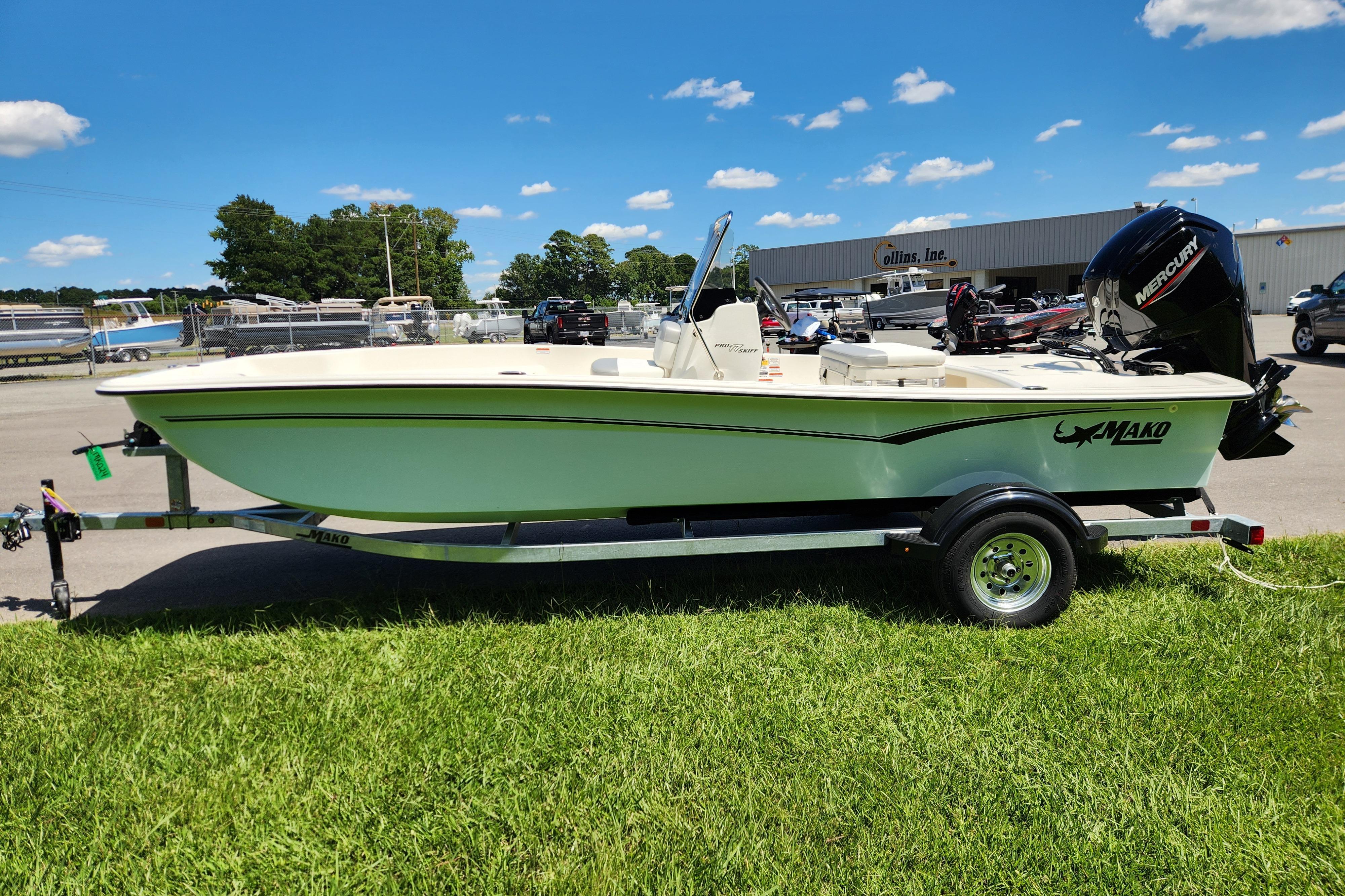 2026 Mako Pro Skiff 17 CC boat on trailer, parked on grass under blue sky.