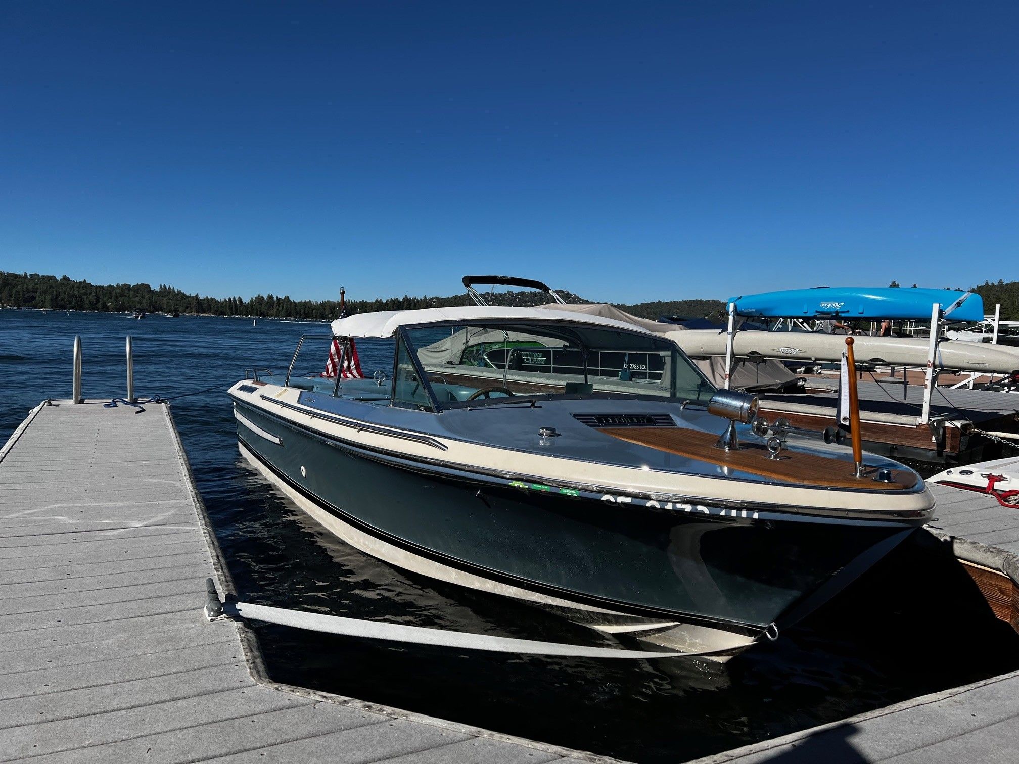 1985 Century Coronado Cardel boat docked on a sunny lake with clear blue skies.