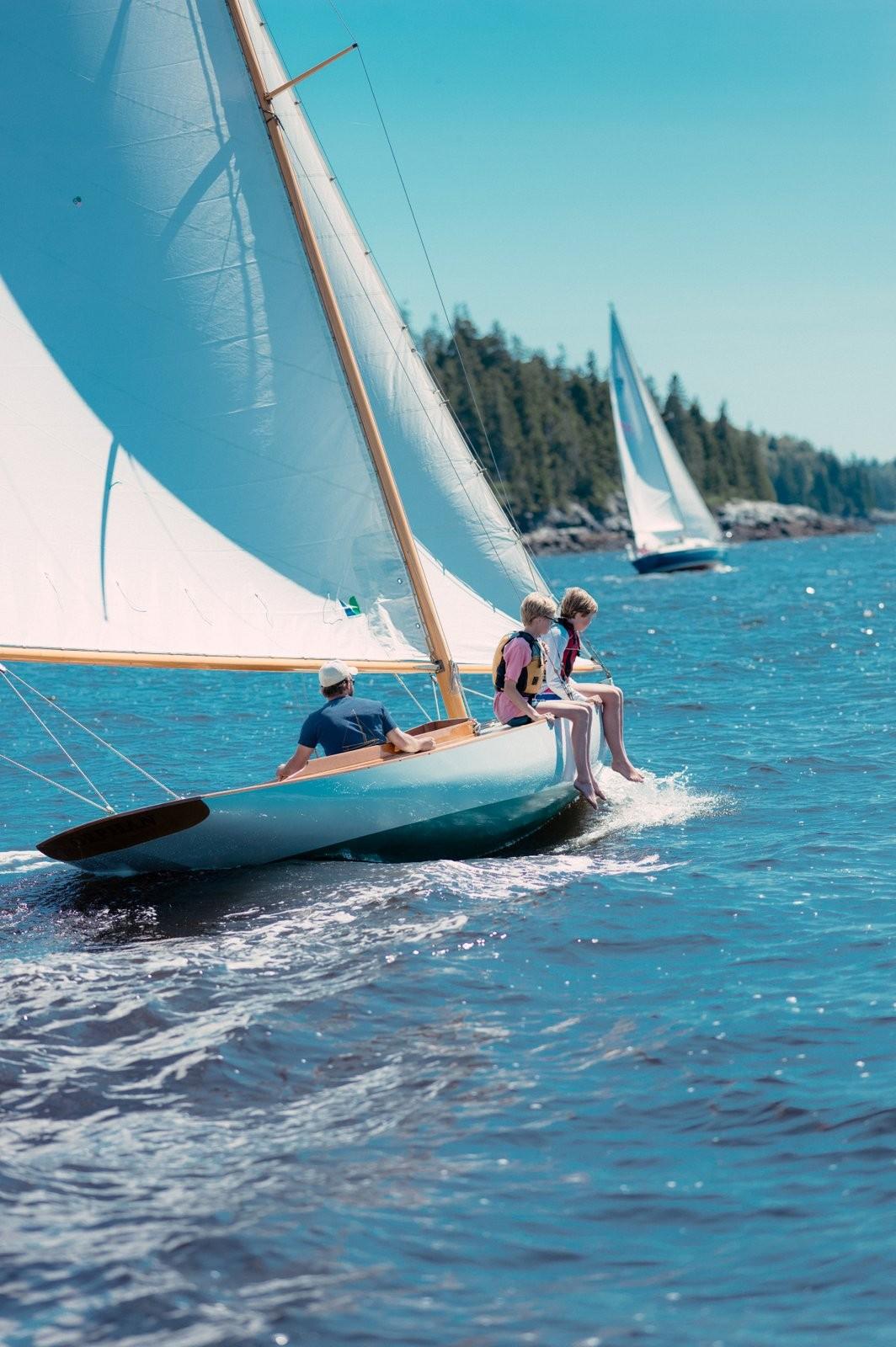 Sailing on a 1994 Herreshoff Watch Hill 15 in sunny, clear waters.