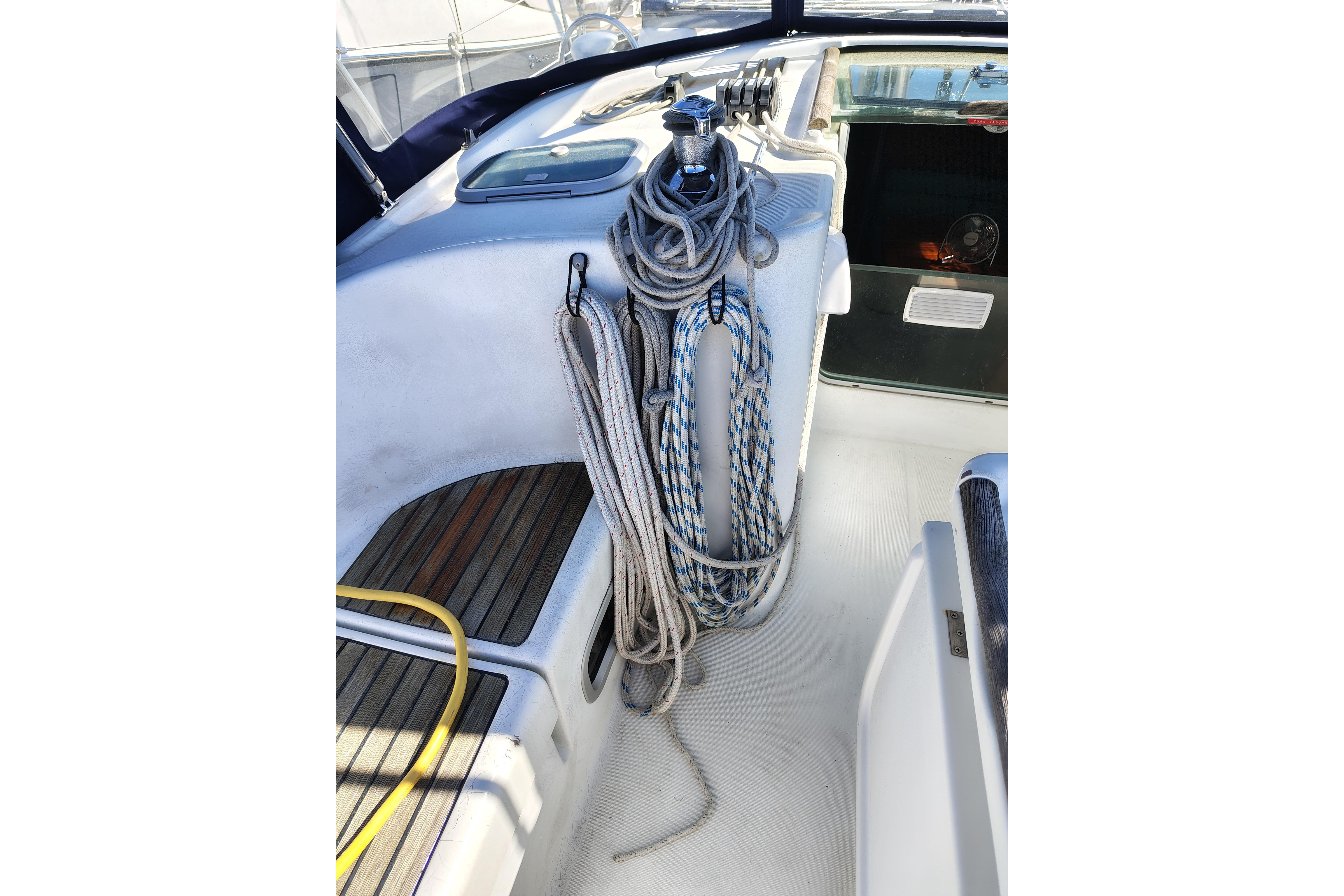 Cockpit of 2001 Beneteau Oceanis 411 sailboat with ropes and winch.