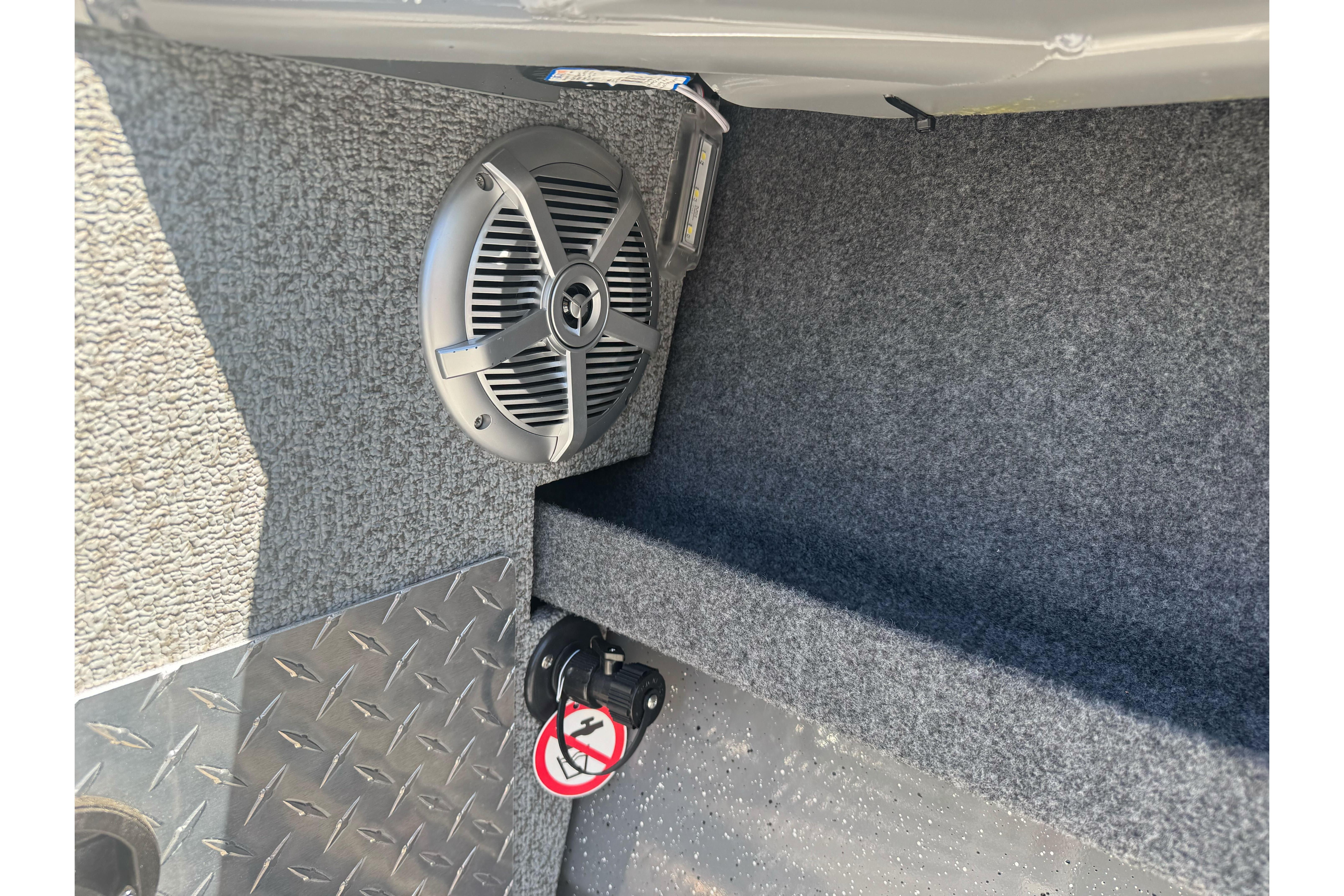Interior of 2026 Lund 210 Heavy Gauge boat with speaker and textured flooring.