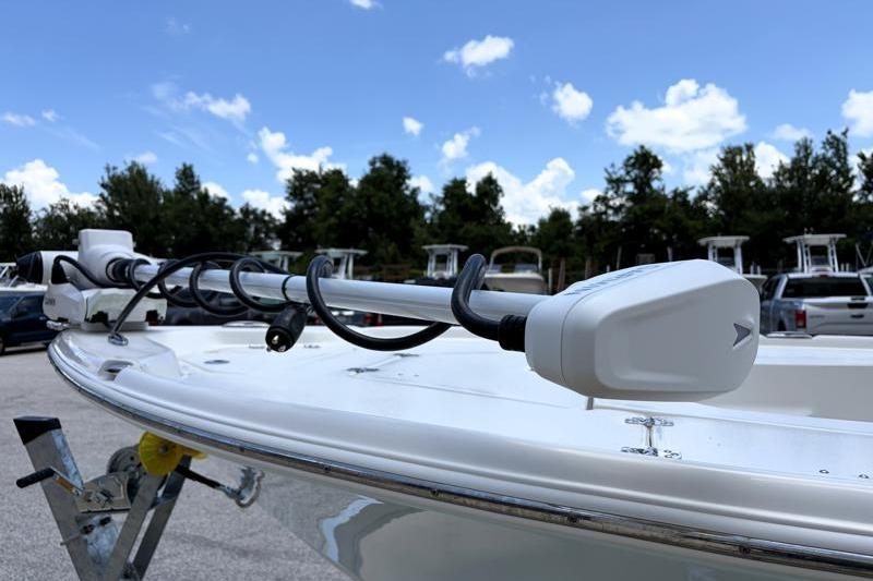 2025 Key West 210 Bay Reef boat with trolling motor, parked outdoors under blue sky.