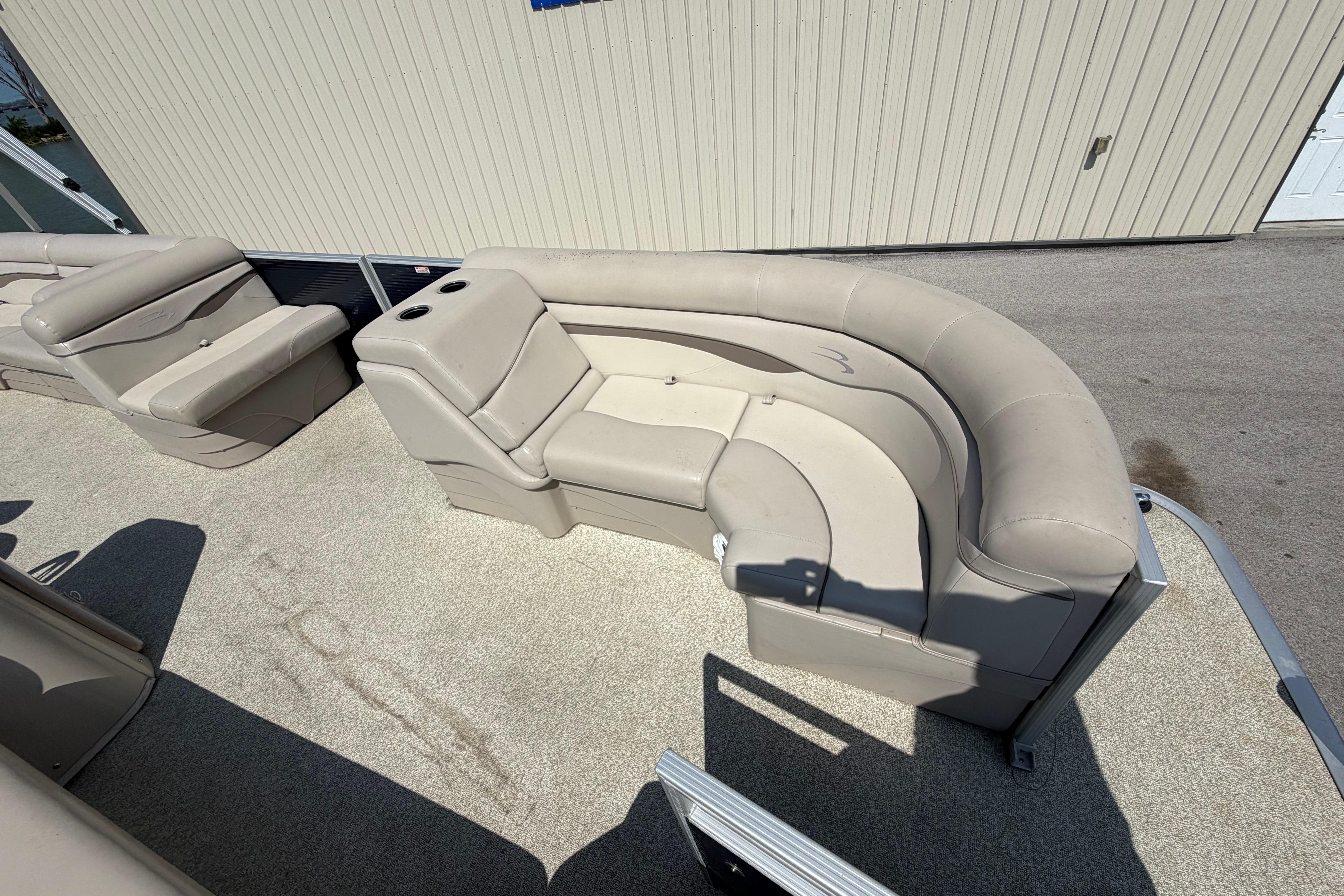 2017 Bennington 25 SSXAPG pontoon boat with beige seating and cup holders.