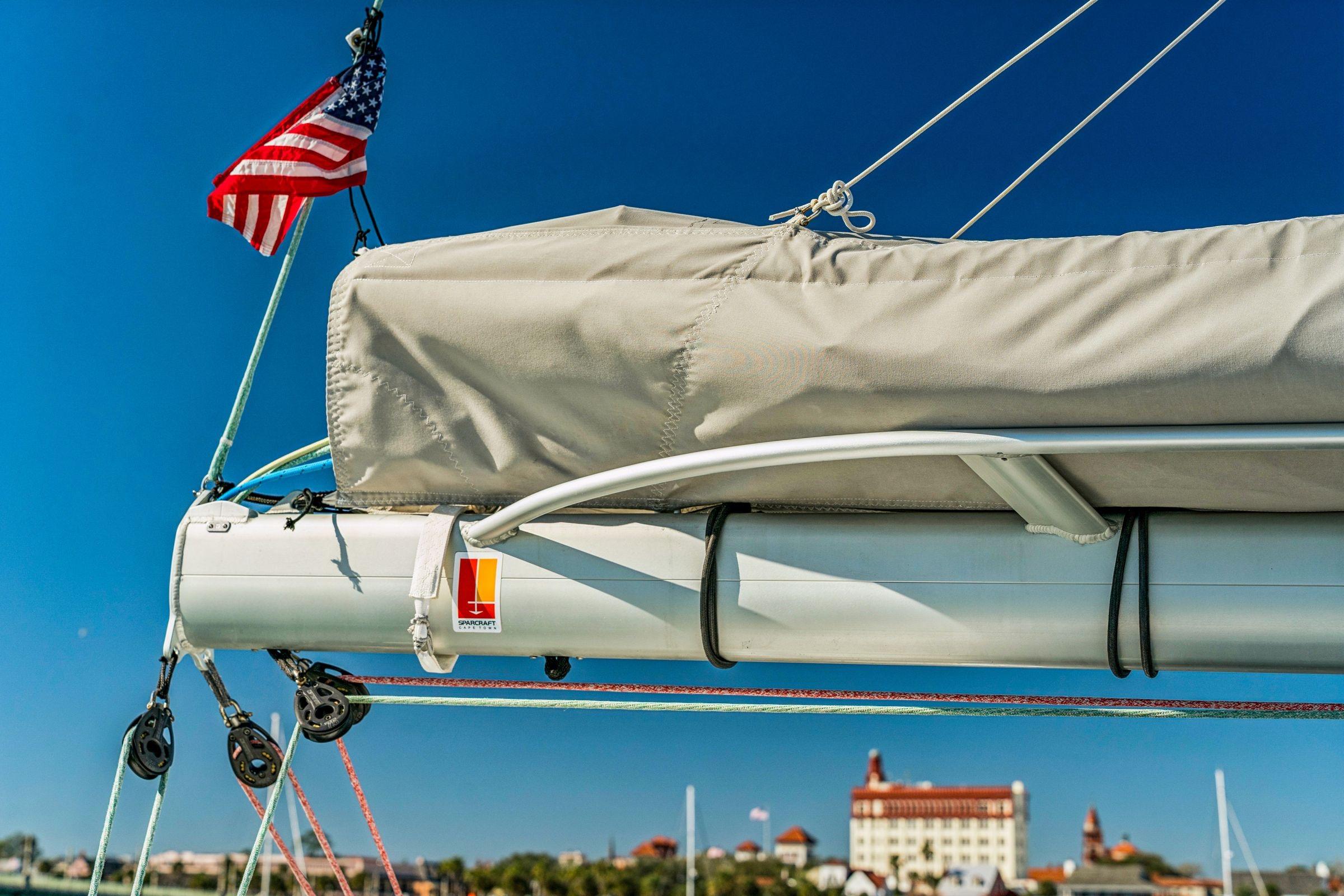 Sailboat rigging with American flag, Balance 482 model, 2024, against clear blue sky.