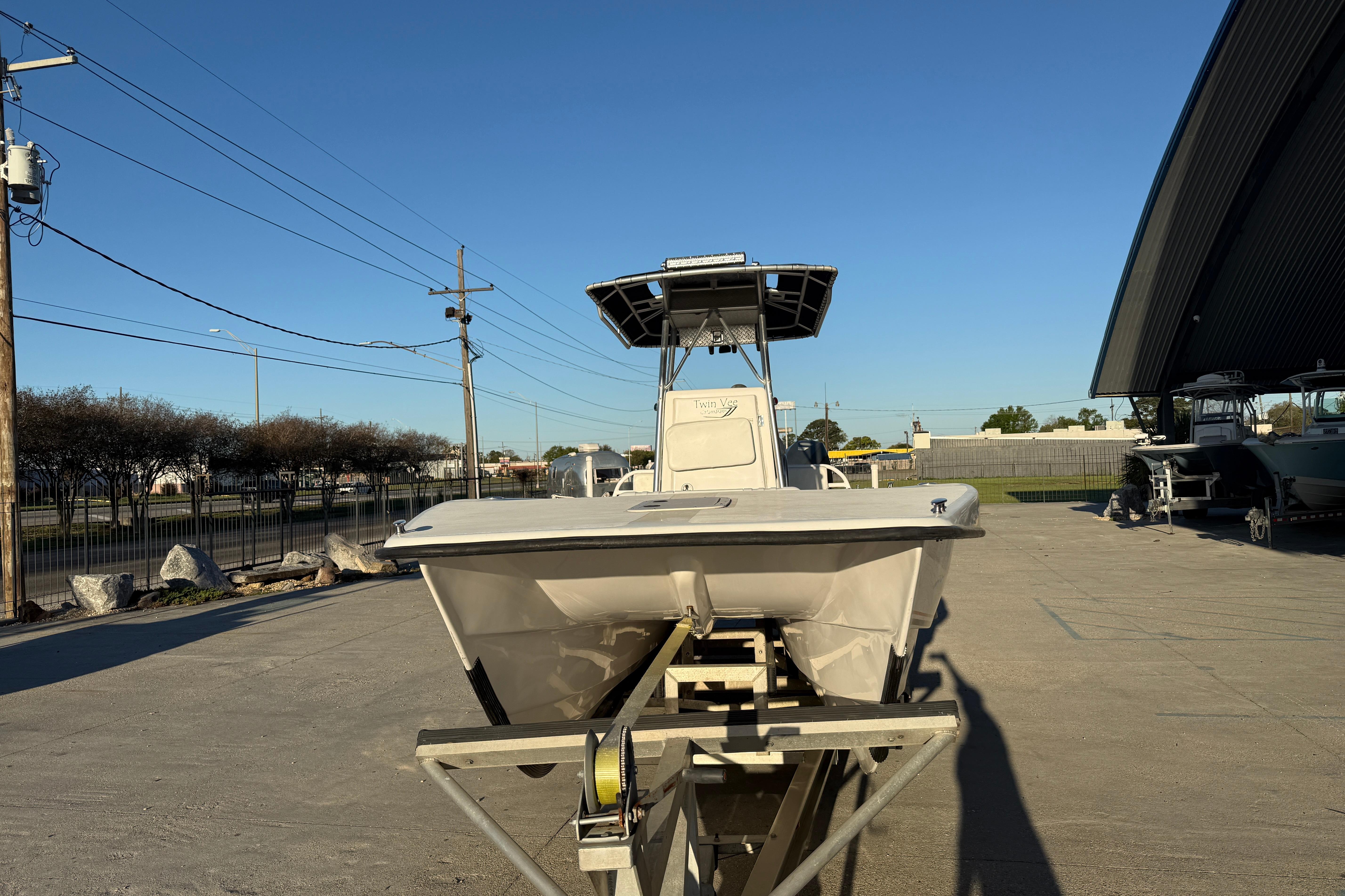 2007 Twin Vee 26 Center Console boat on trailer in outdoor storage area.