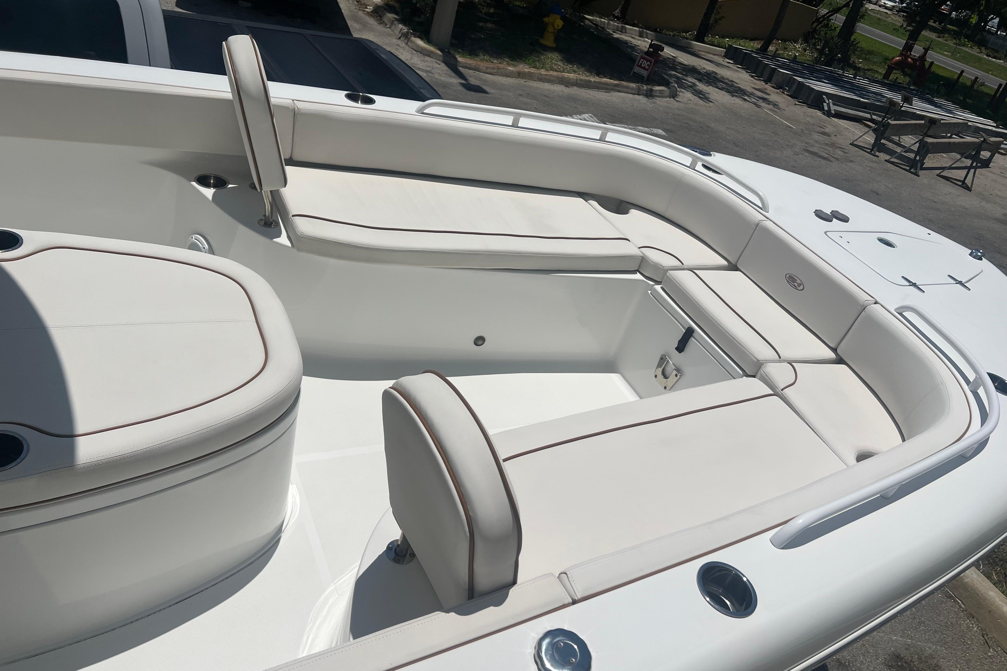 2022 Sea Hunt Escape 27 boat interior with white cushioned seating and storage compartments.