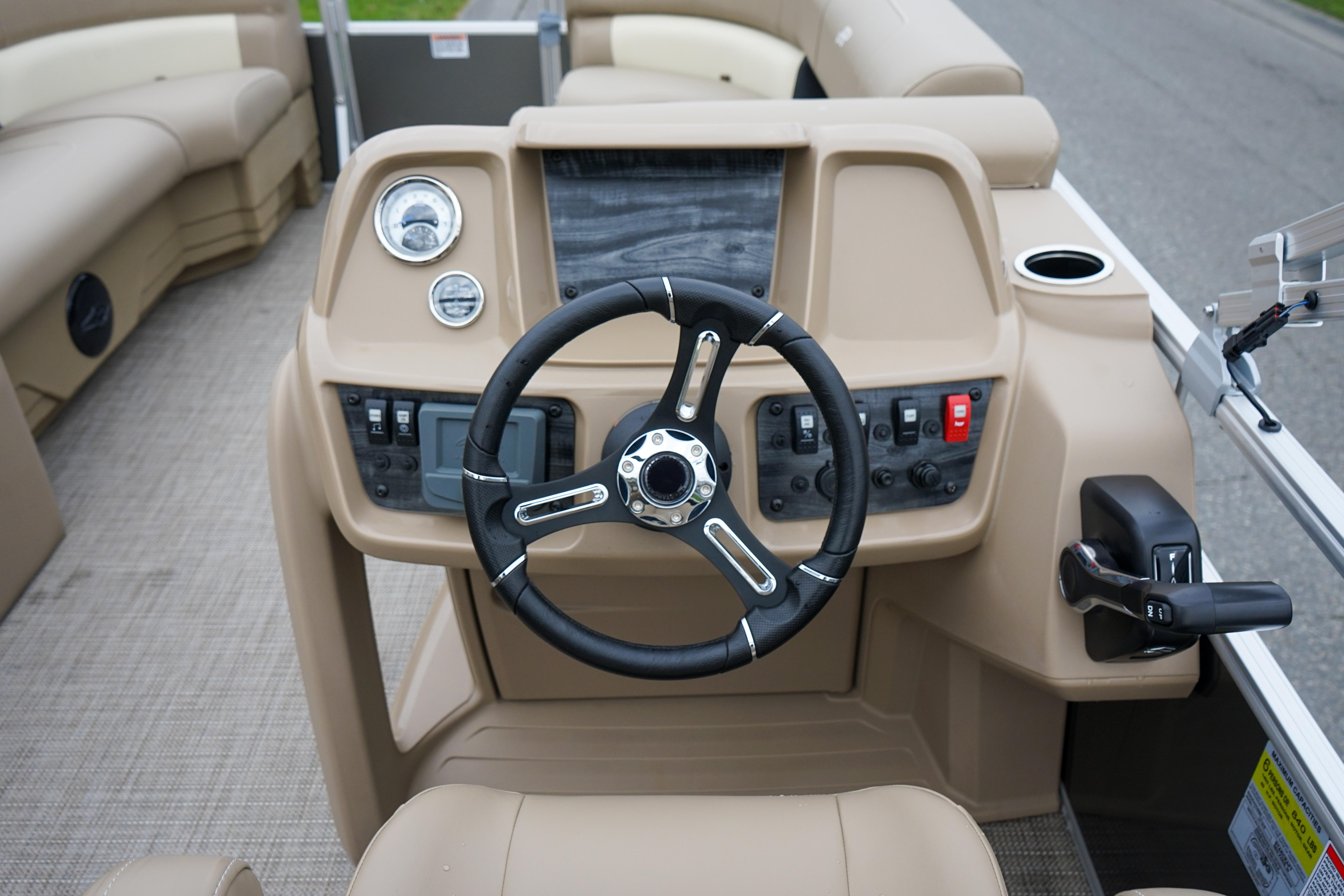 Steering console of 2025 Starcraft LX16R boat with beige interior and controls.