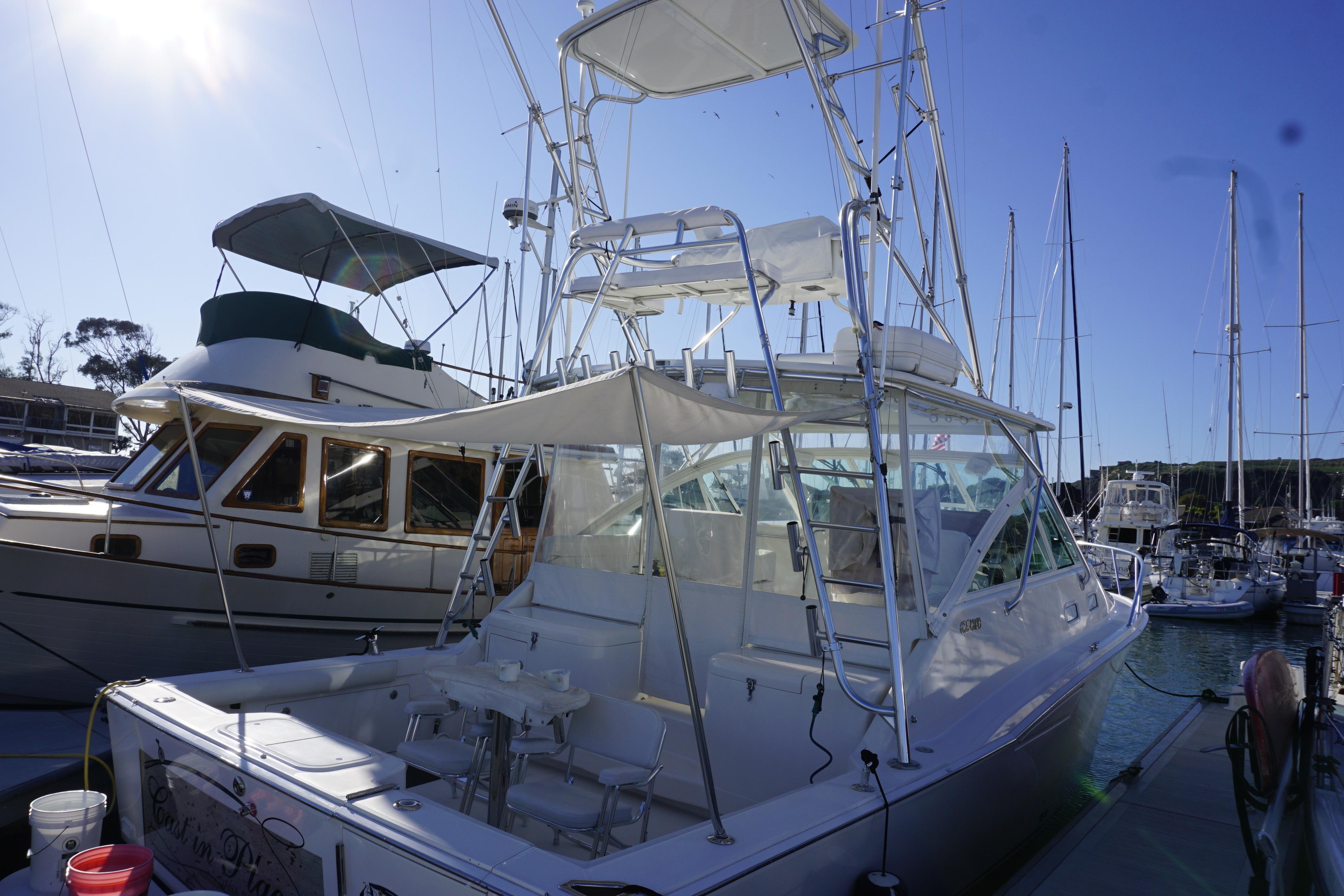 2005 Cabo 35 Express boat docked at marina under clear blue sky.