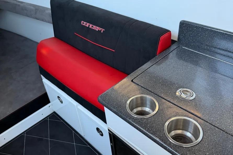 Interior of 2021 Concept 44' Open Deck with red and black seating, sleek countertop.