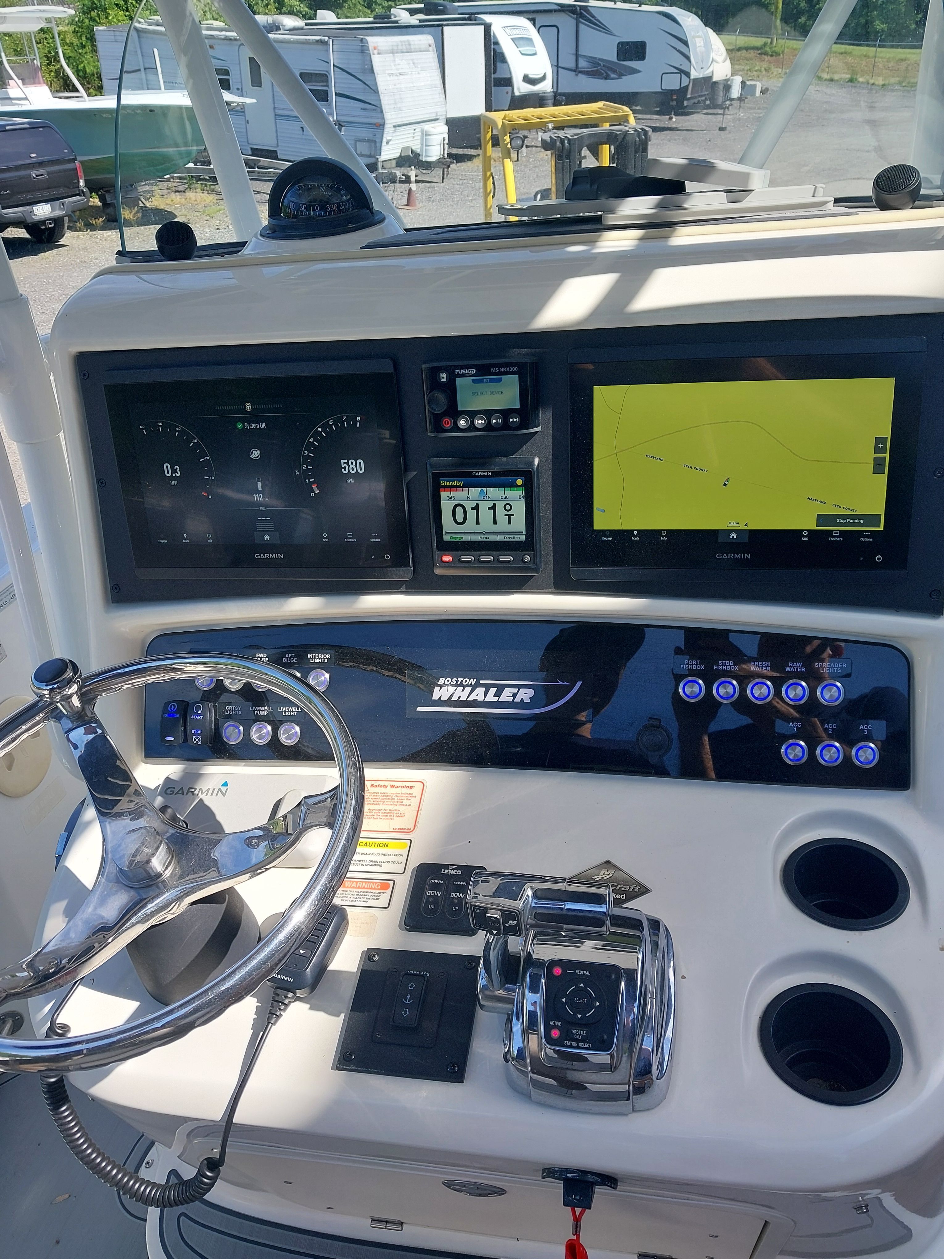 The image shows the helm of a 2005 Boston Whaler 240 Outrage with modern instruments.