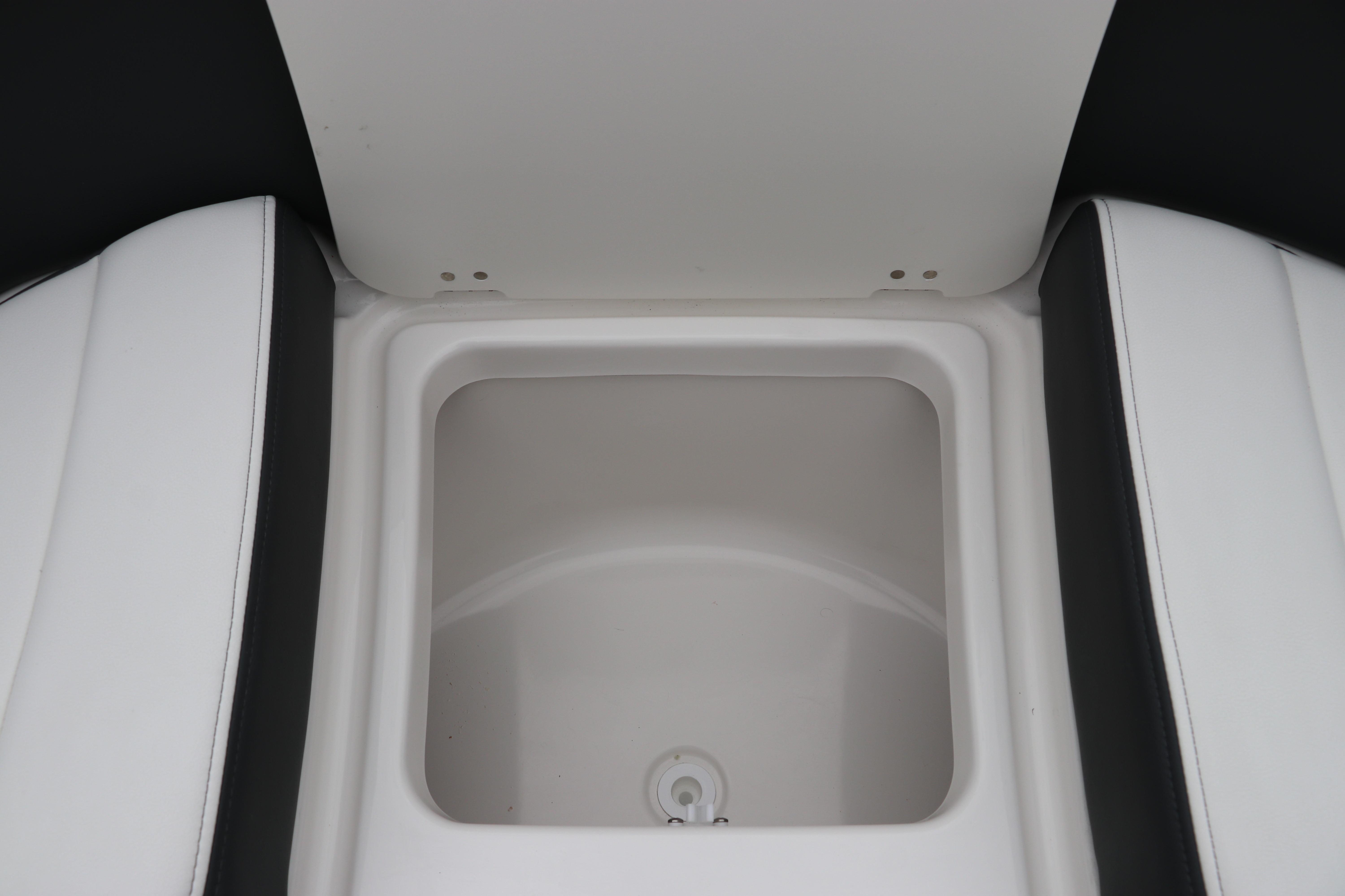 2026 Chaparral 270 OSX boat storage compartment with white and black seating.