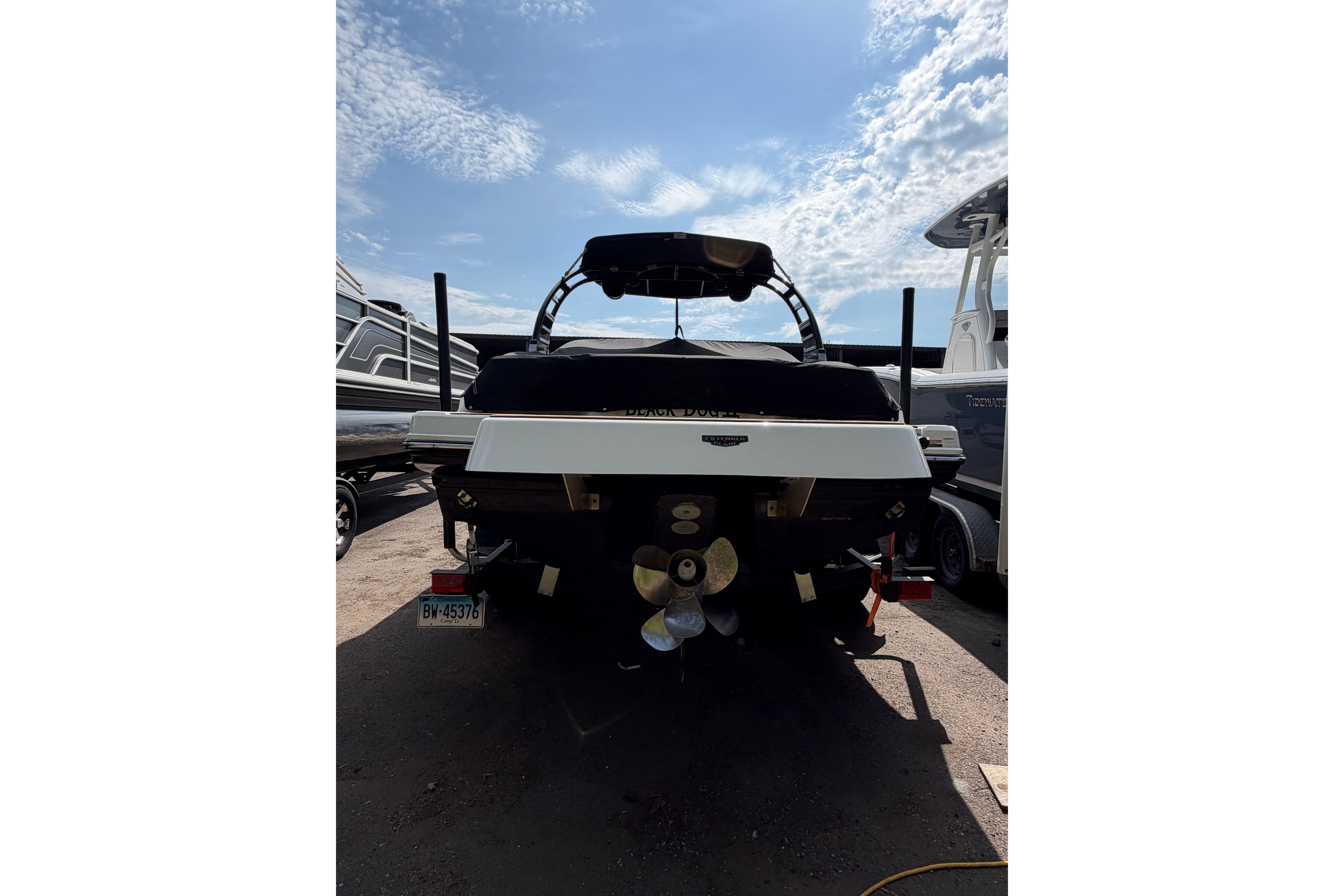 Rear view of 2025 Chaparral 230 SSi boat under a clear blue sky.