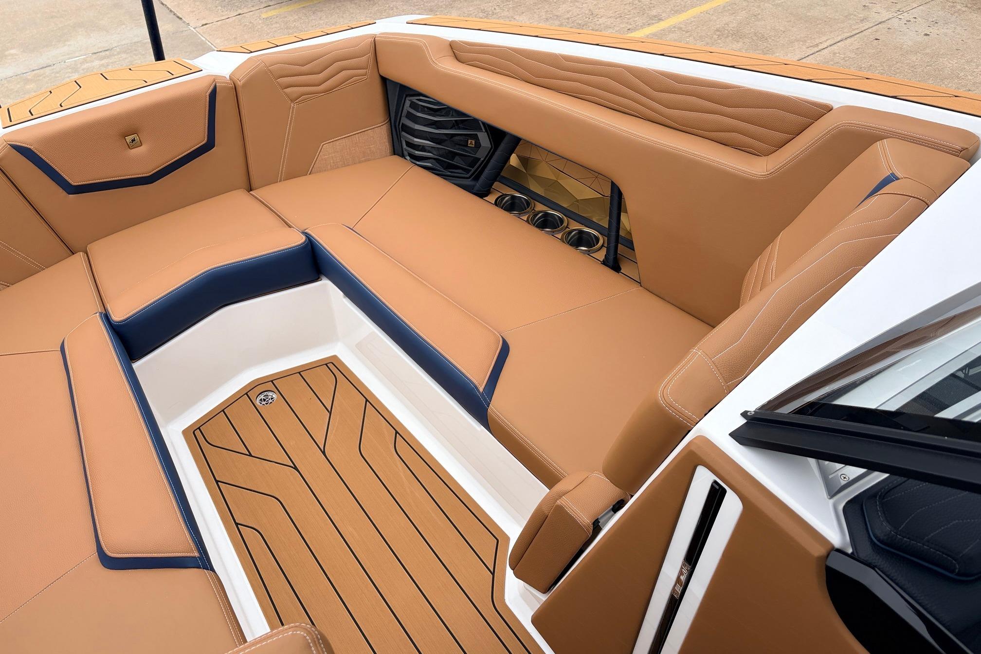 2026 Nautique Super Air Nautique G25 interior with tan and navy seating, cup holders, and teak flooring.
