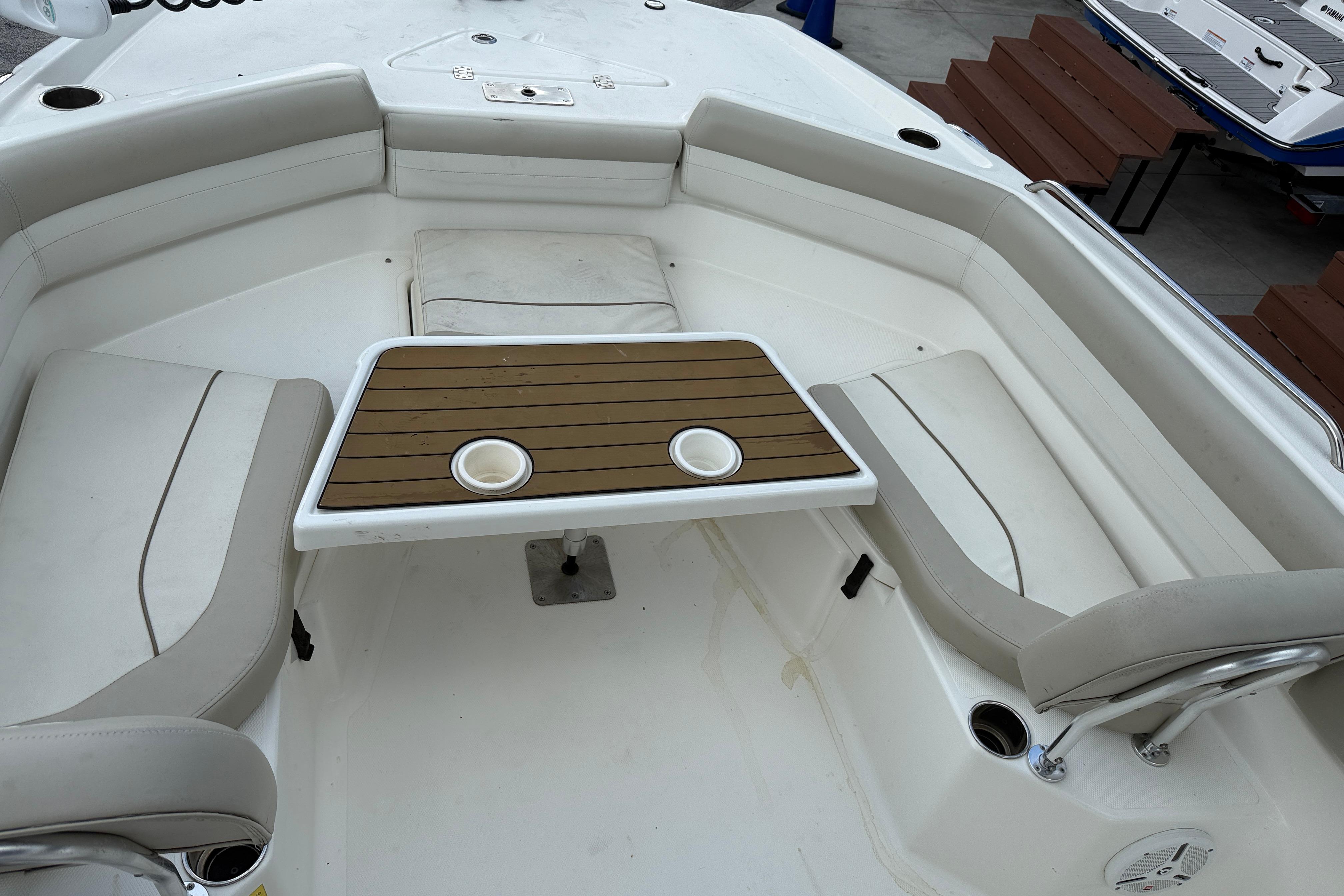2015 NauticStar 231 Coastal boat interior with seating and table setup.
