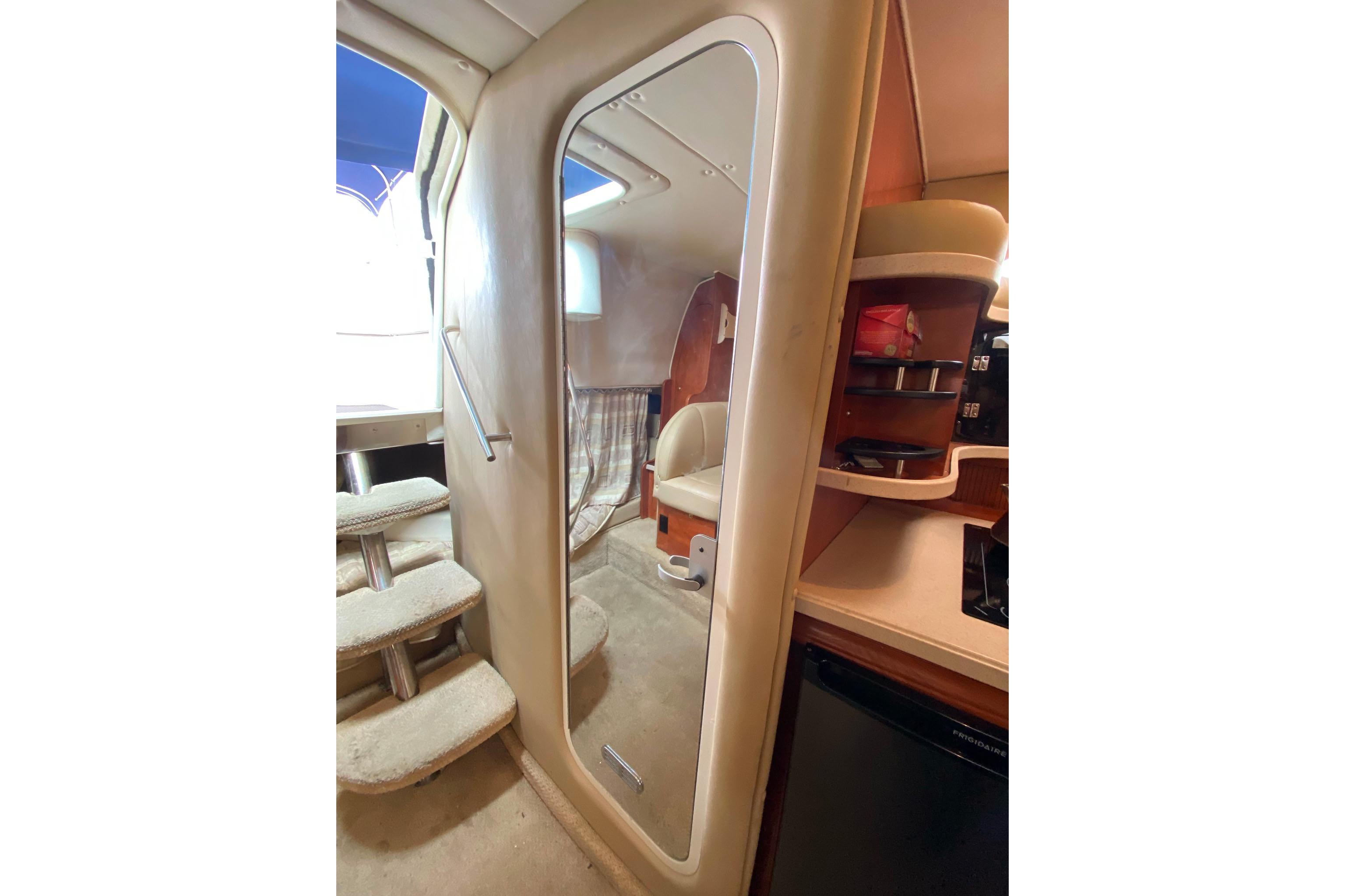 Interior of 2003 Rinker Fiesta Vee 342 boat, featuring stairs and kitchenette area.