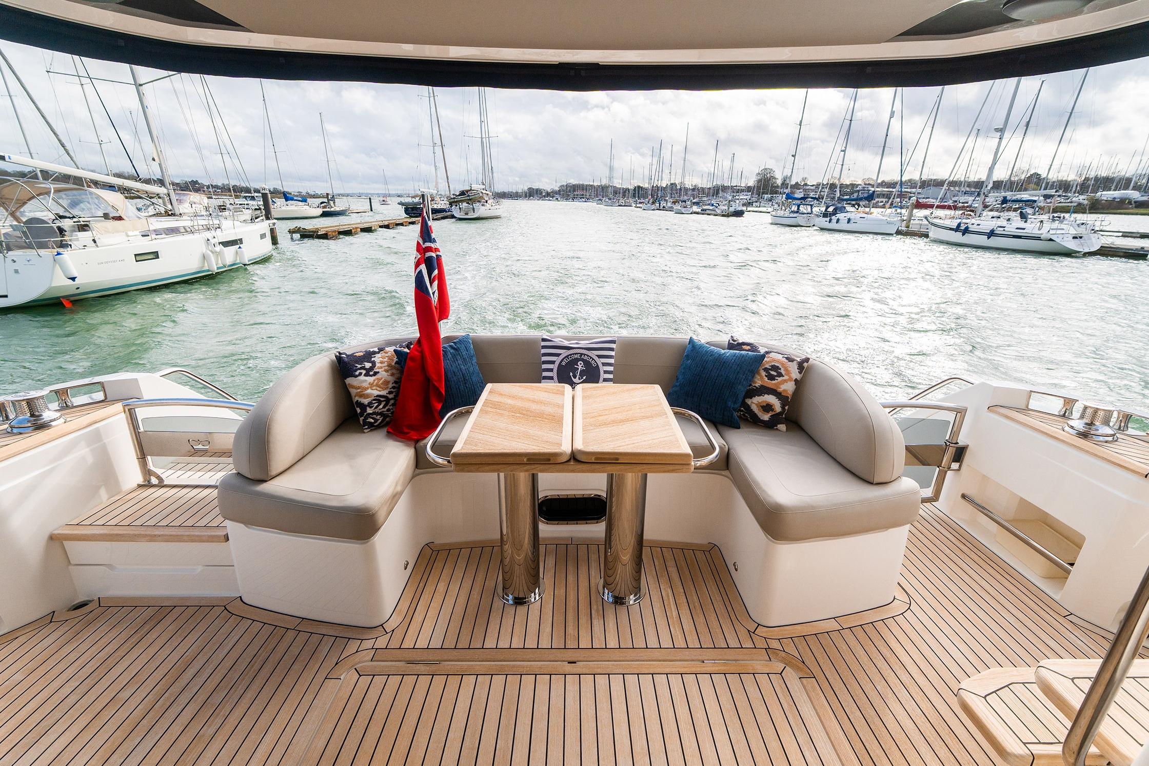 Luxurious 2020 Princess F55 yacht deck with seating and scenic marina view.