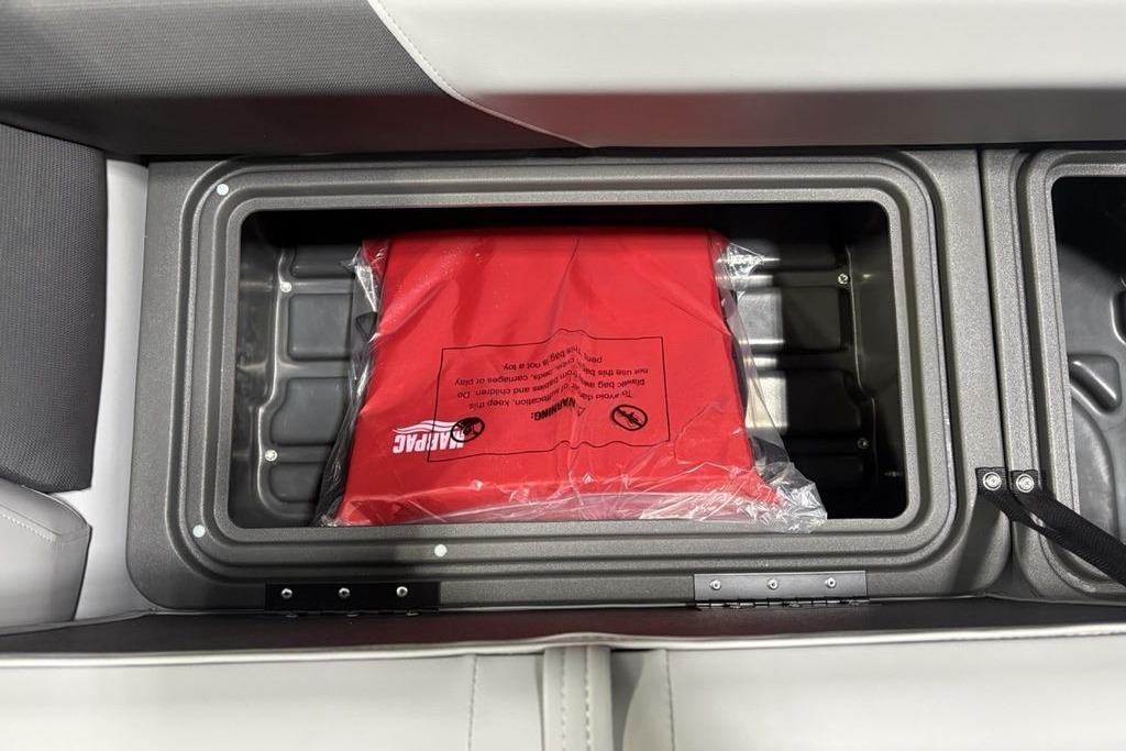 Storage compartment in 2026 Sun Tracker PARTY BARGE® 20 DLX with red life jacket.