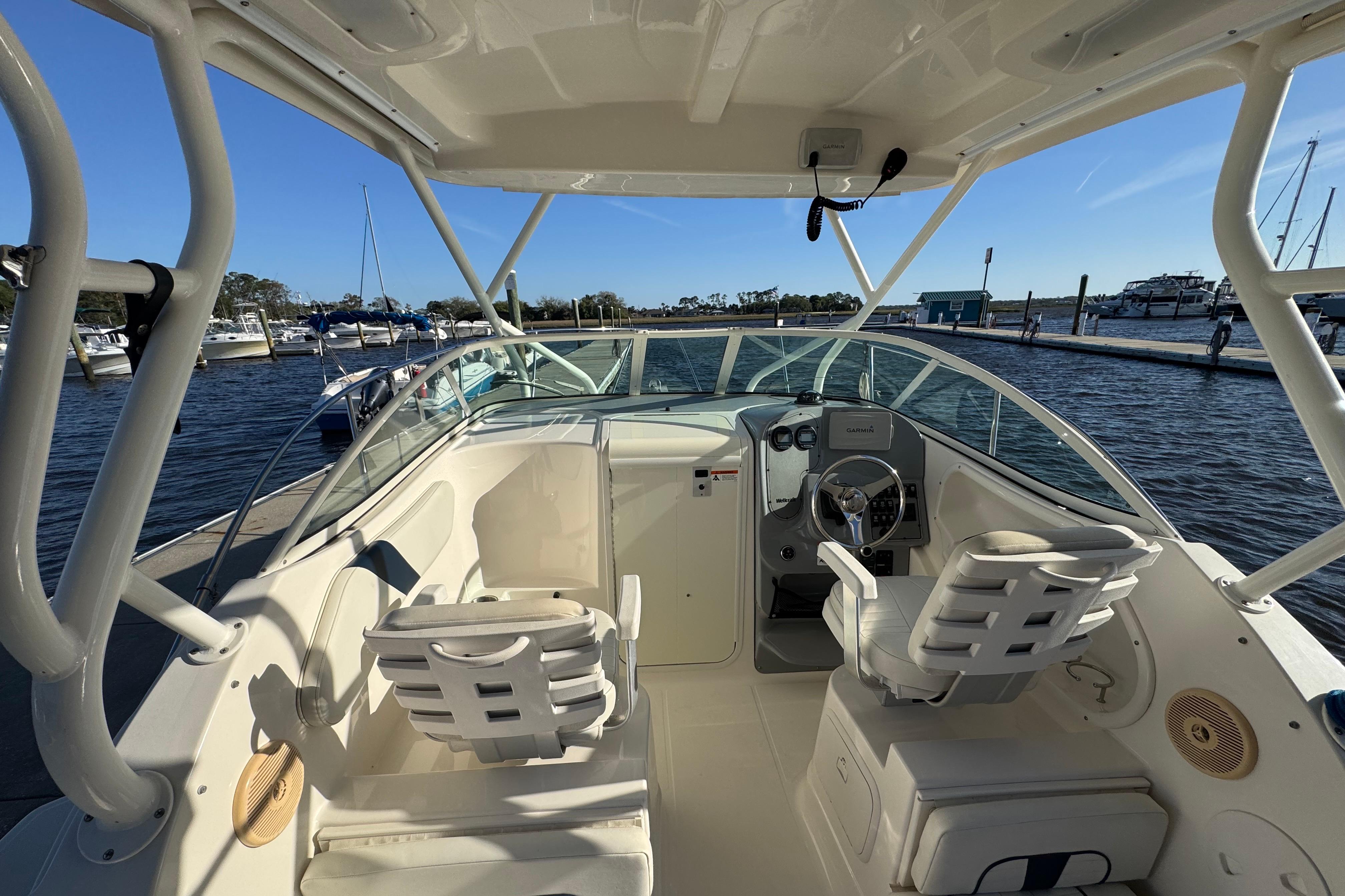 2014 Wellcraft 252 Coastal boat interior at marina, featuring helm and seating.