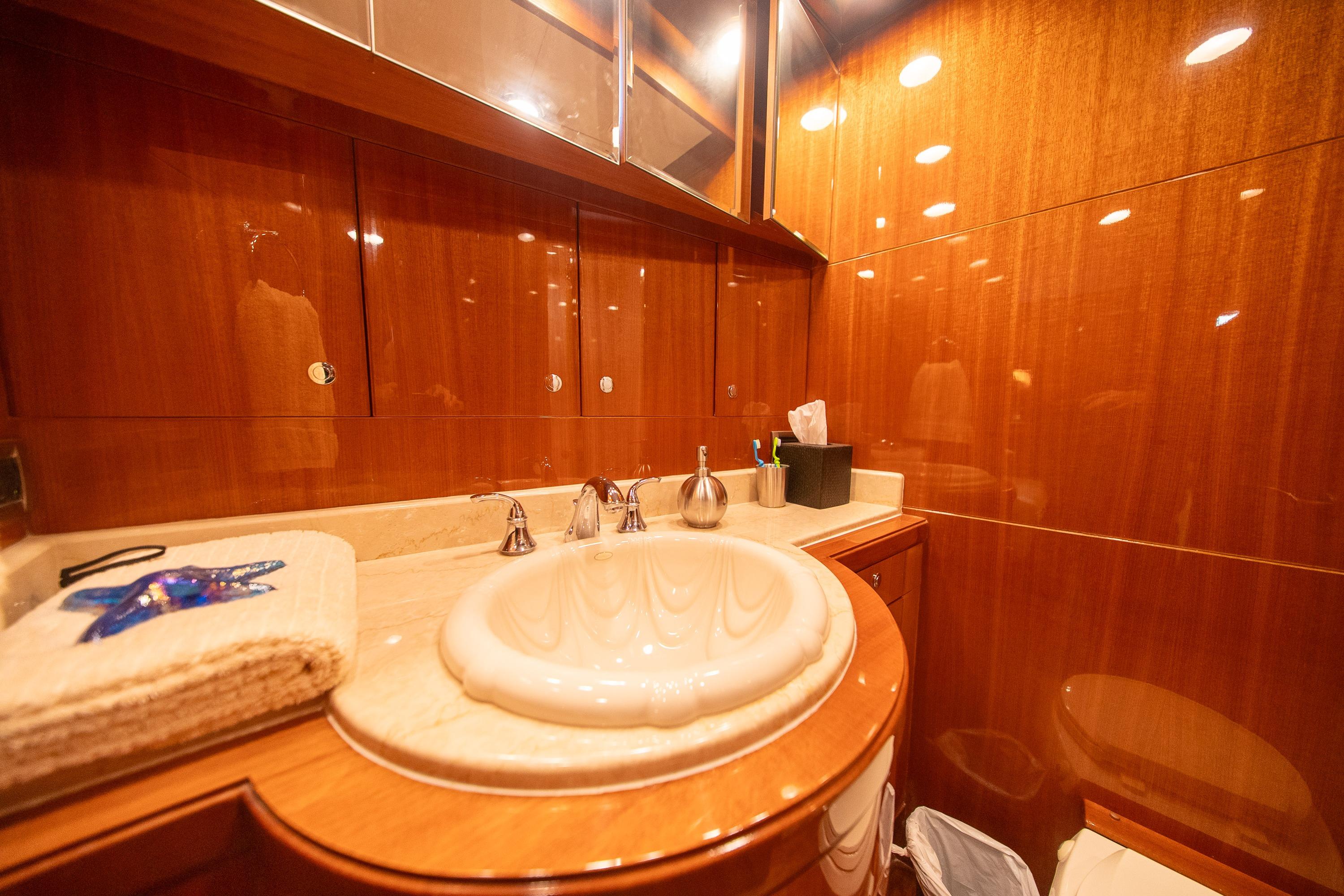 Luxurious bathroom in 2007 Ocean Alexander 74 Pilothouse yacht with elegant wood finish.