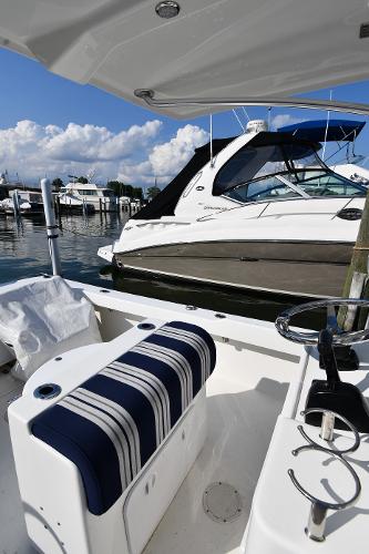 2021 Eastern 248 Center Console boat docked at a marina with a striped seat.