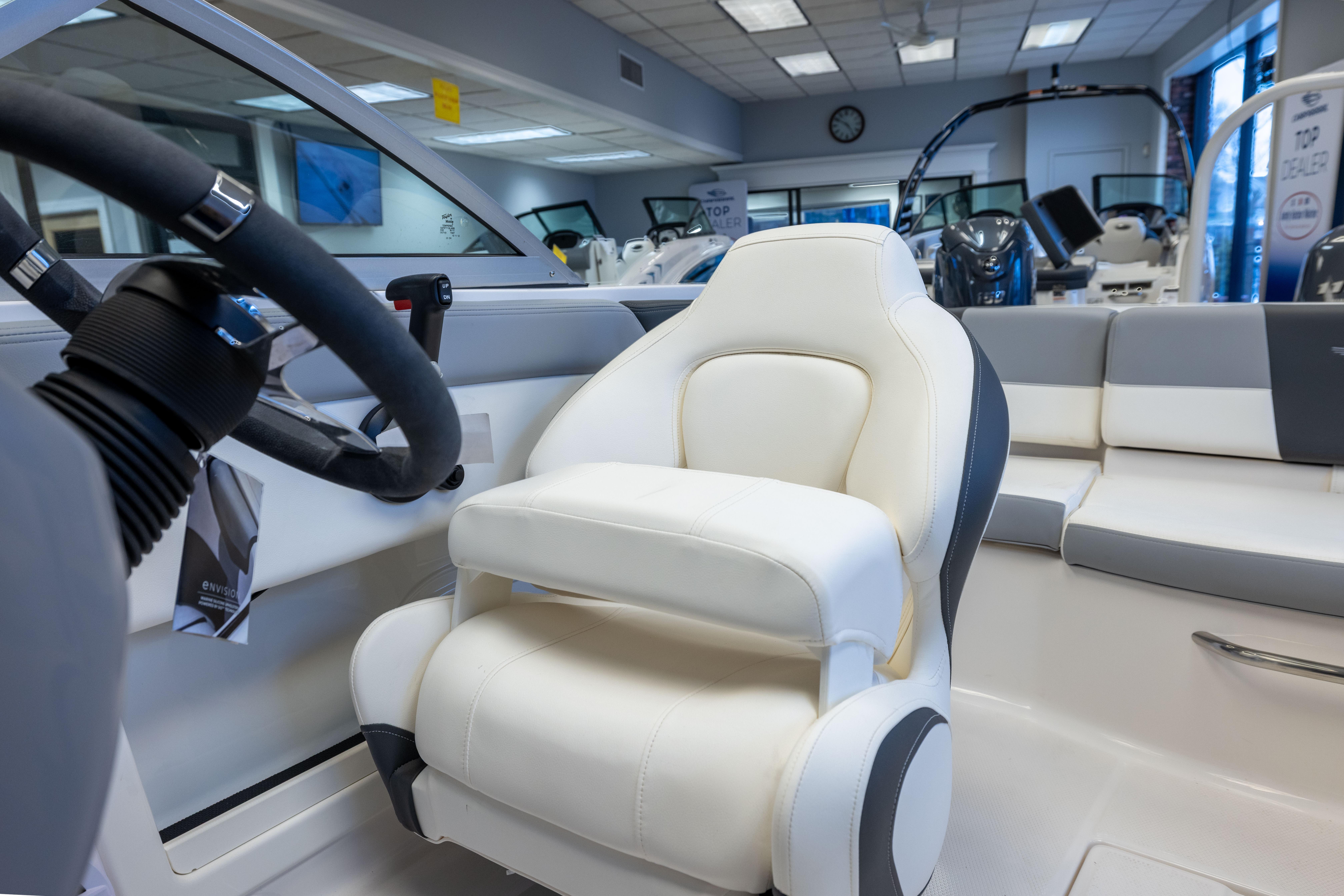 2024 Chaparral 19 SSi OB boat interior with white captain's seat and steering wheel.