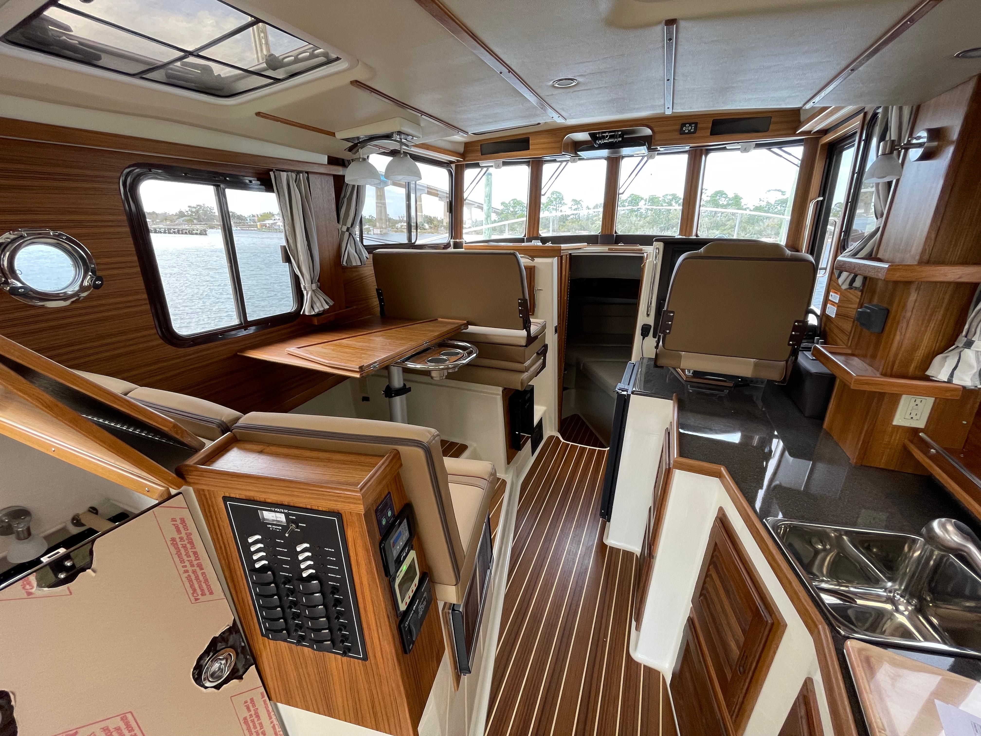 2023 Ranger Tugs R-31 CB interior with wood accents and panoramic windows.