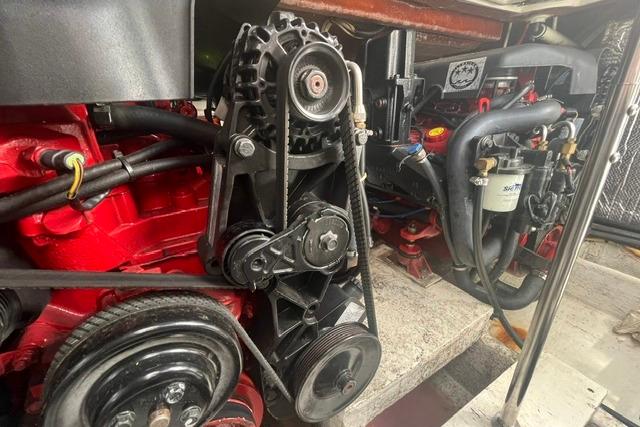 Engine compartment of 2004 Cruisers Yachts 3372 Express, showcasing mechanical components and belts.