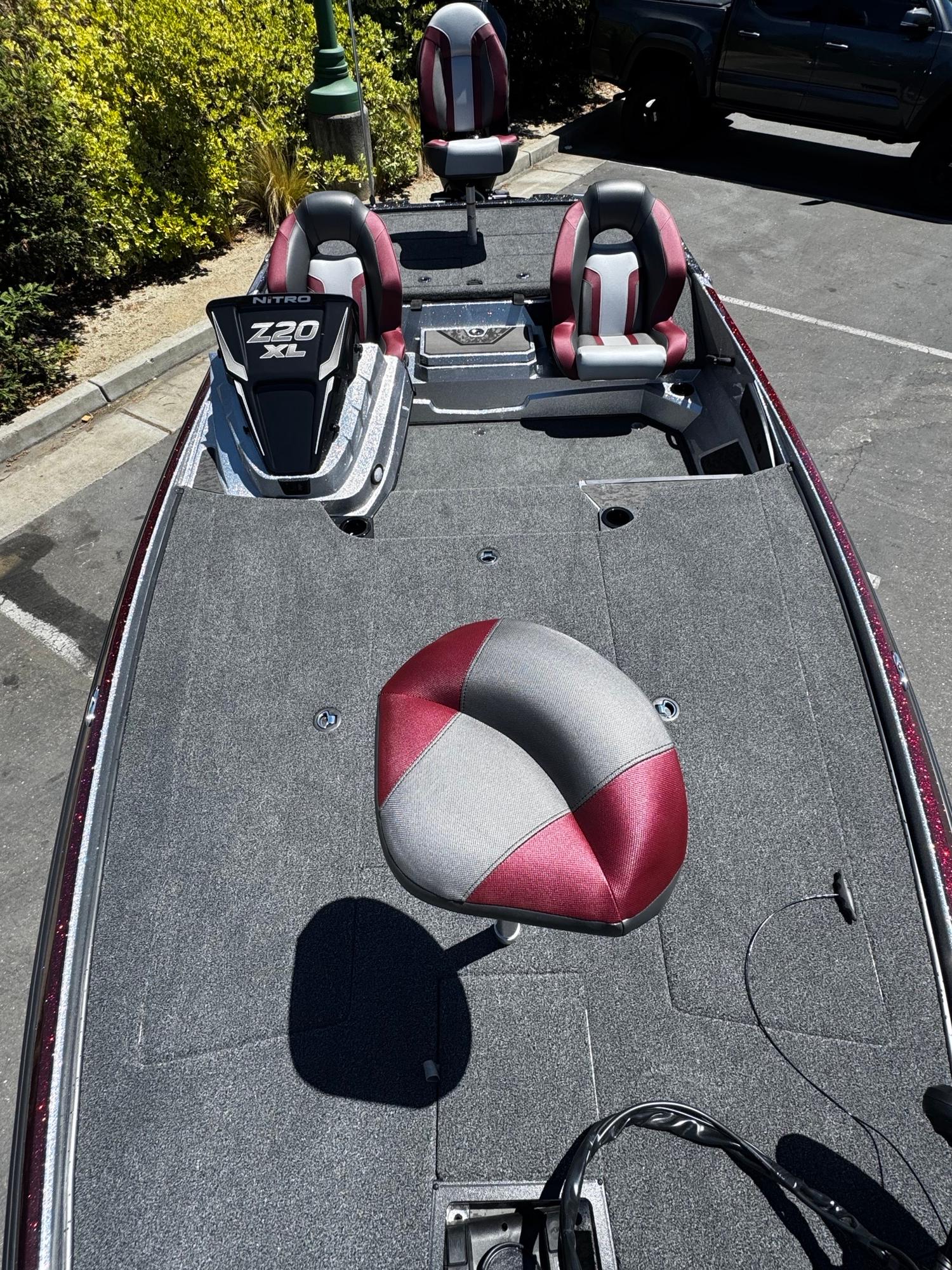 2025 Nitro Z20 XL Pro fishing boat with red and gray seats in a parking lot.