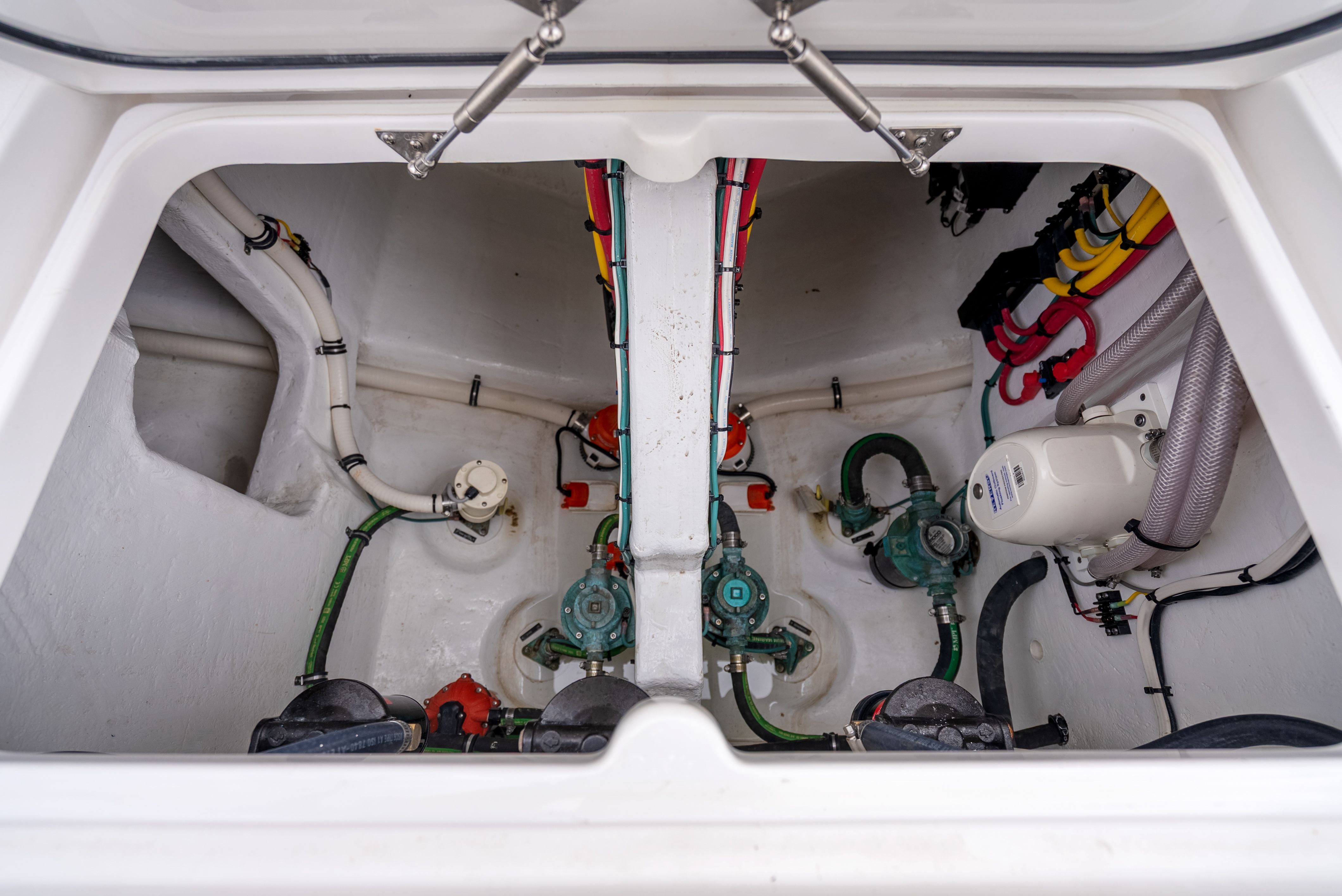 Intrepid 477 Evolution 2024 engine compartment with hoses and valves.