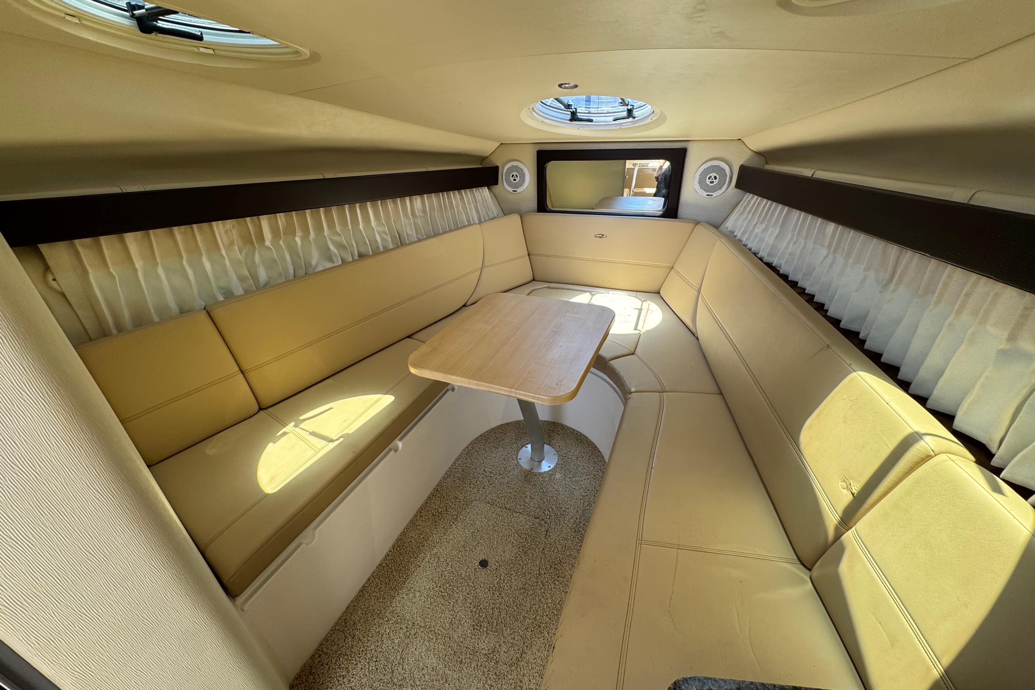 Interior of 2013 Regal 28 Express boat with beige seating and wooden table.