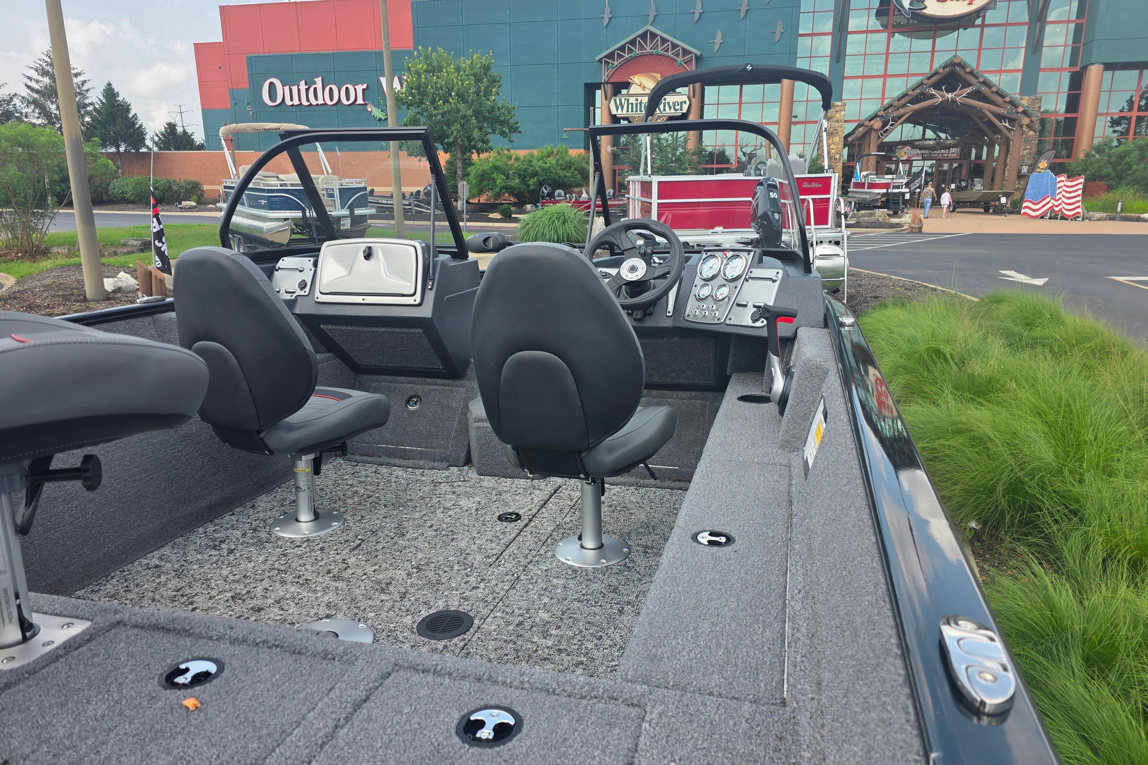 2026 Tracker Pro Guide V-175 Combo boat interior with seating and control panel, parked outdoors.
