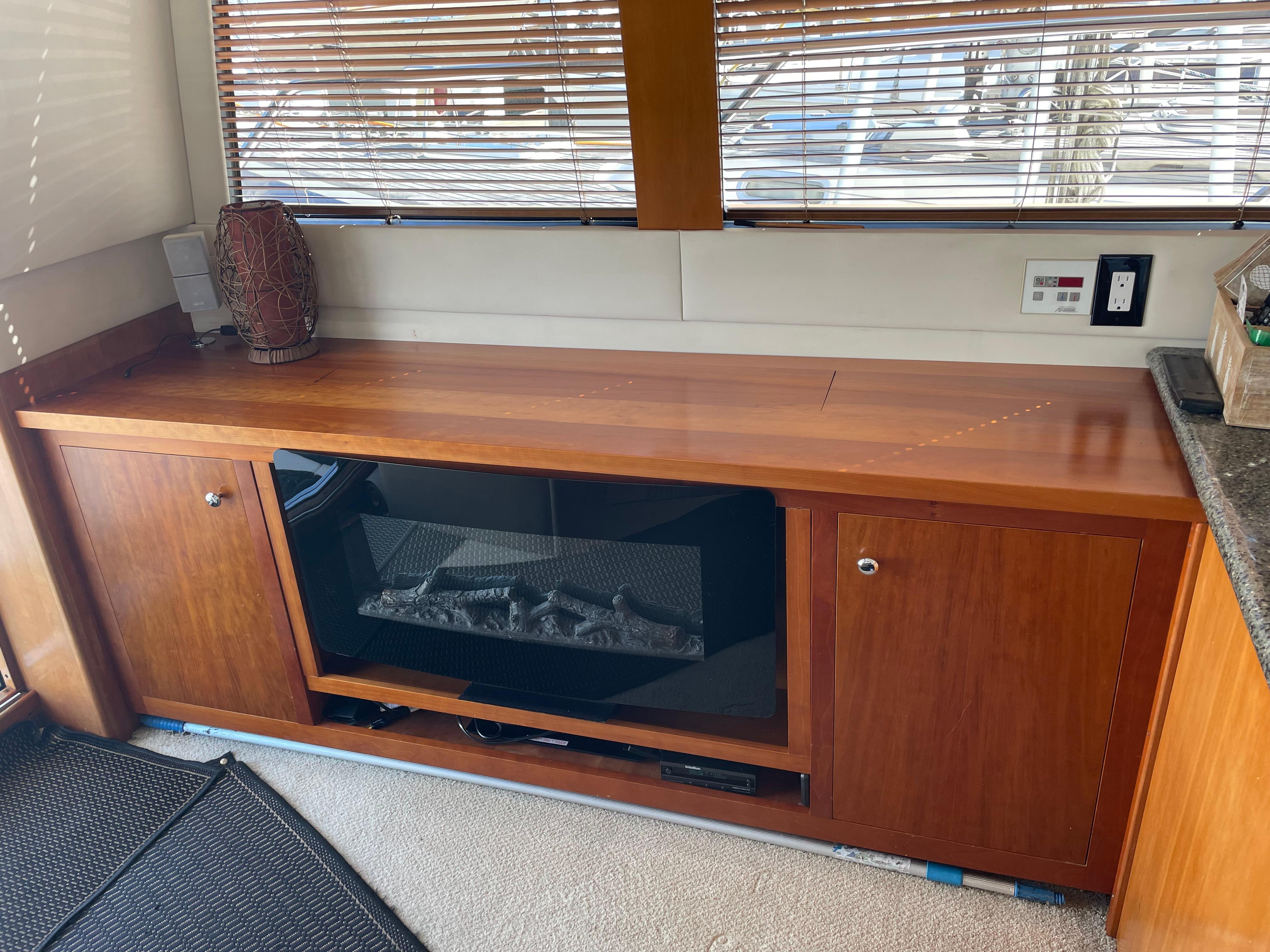 Interior of 2000 Carver 530 Voyager Pilothouse with wooden cabinetry and built-in fireplace.