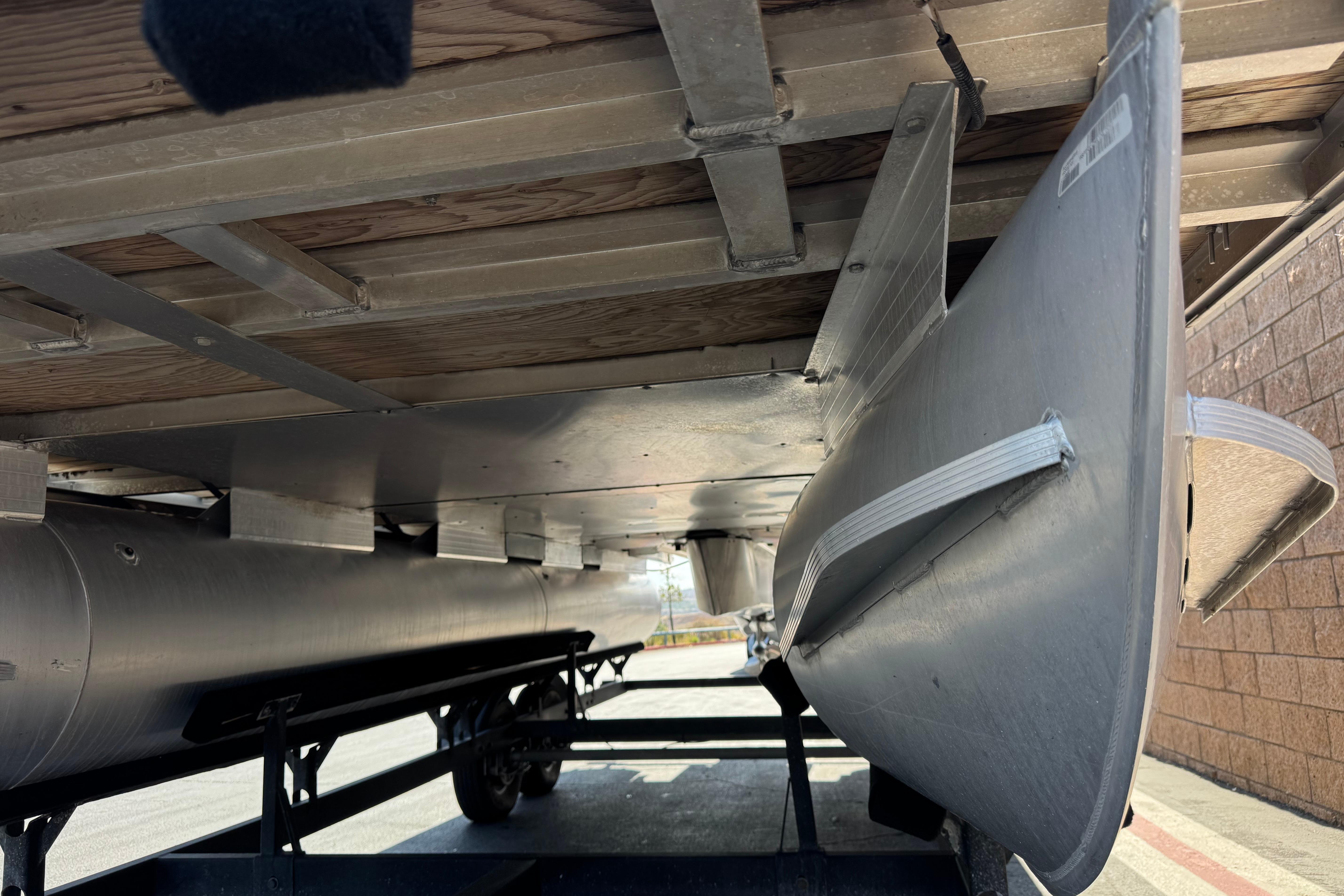Underneath view of a 2018 Sun Tracker SportFish 22 DLX pontoon boat on a trailer.