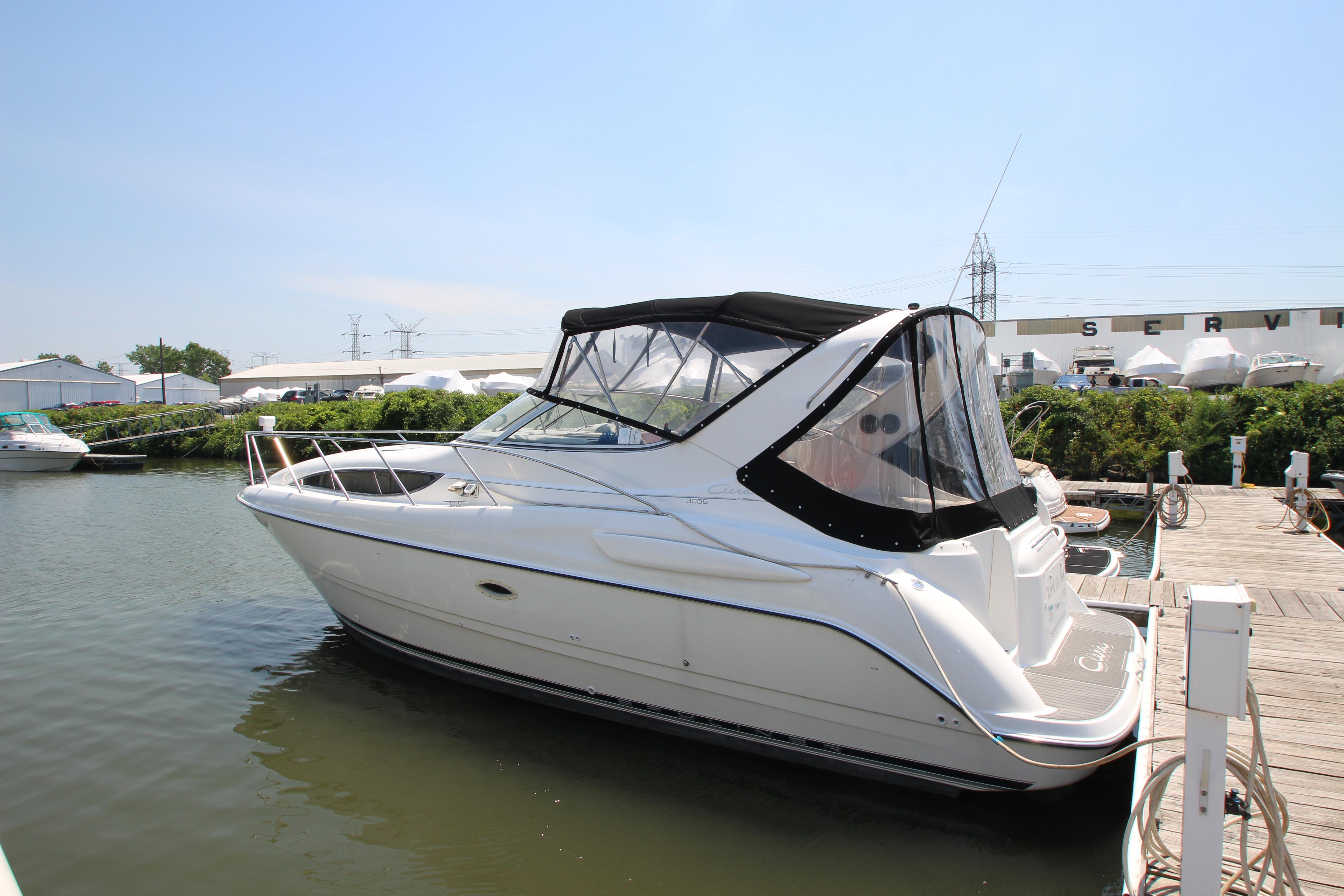 1999 Bayliner 3055 Ciera docked at marina, featuring sleek design and covered cockpit.
