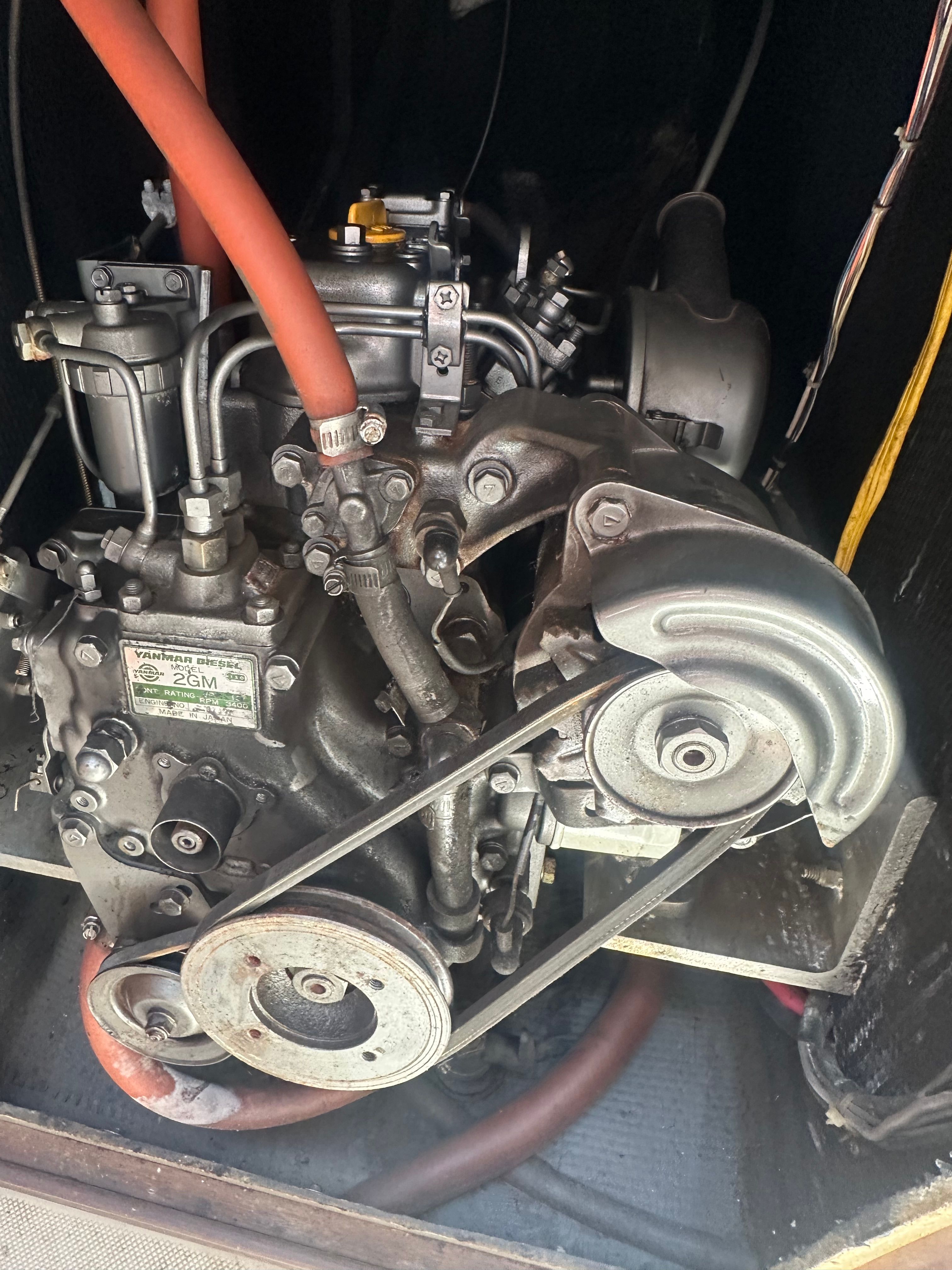 Engine compartment of a 1982 Lancer 30 with visible belts and hoses.