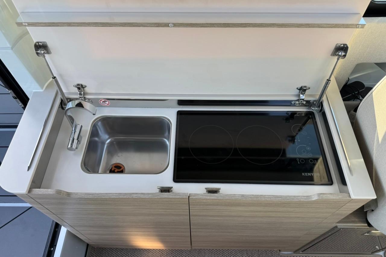 2024 Saxdor 320 GTC kitchenette with sink and electric stove, featuring modern design.