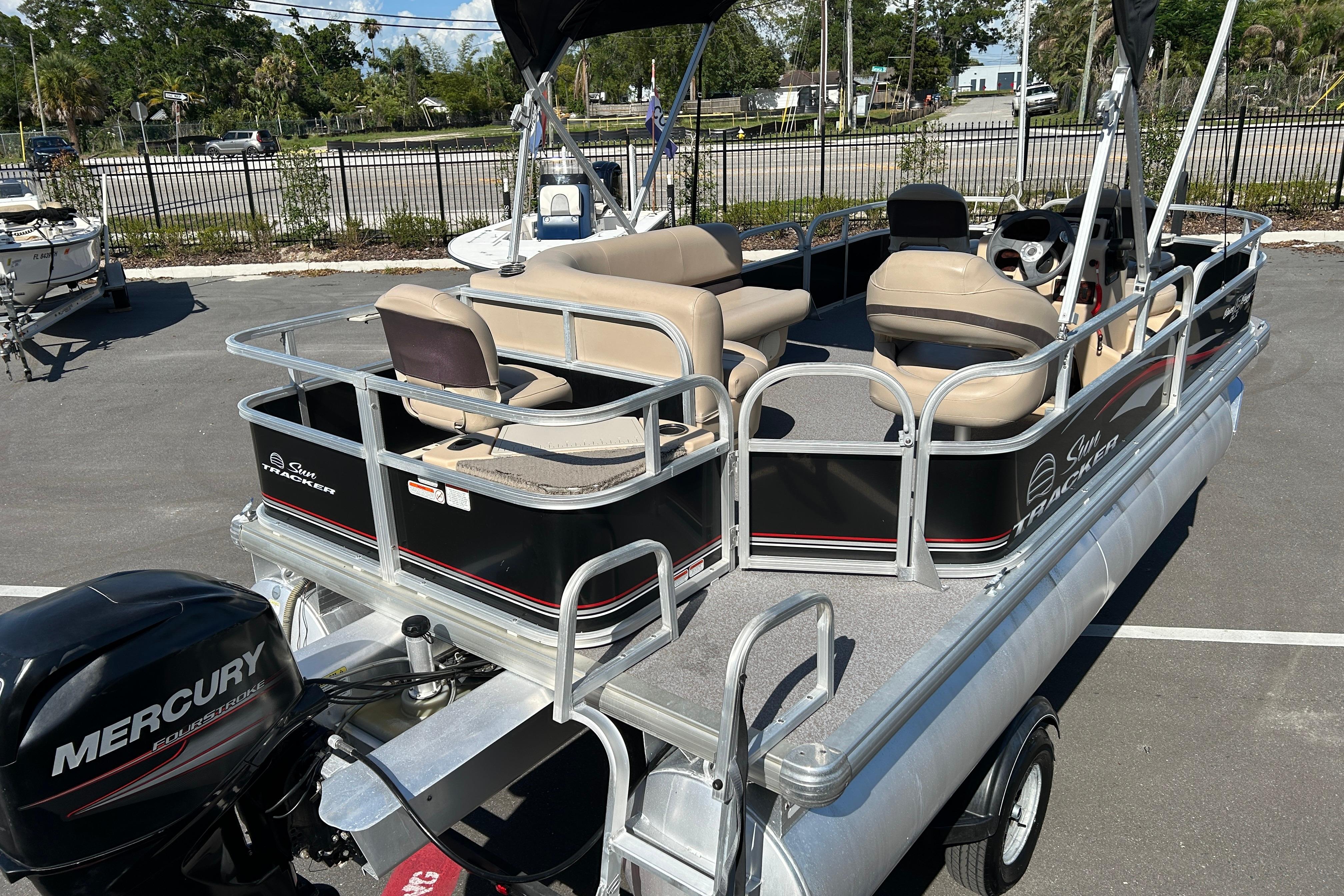 2017 Sun Tracker Bass Buggy 18 DLX pontoon boat with Mercury engine, parked outdoors.