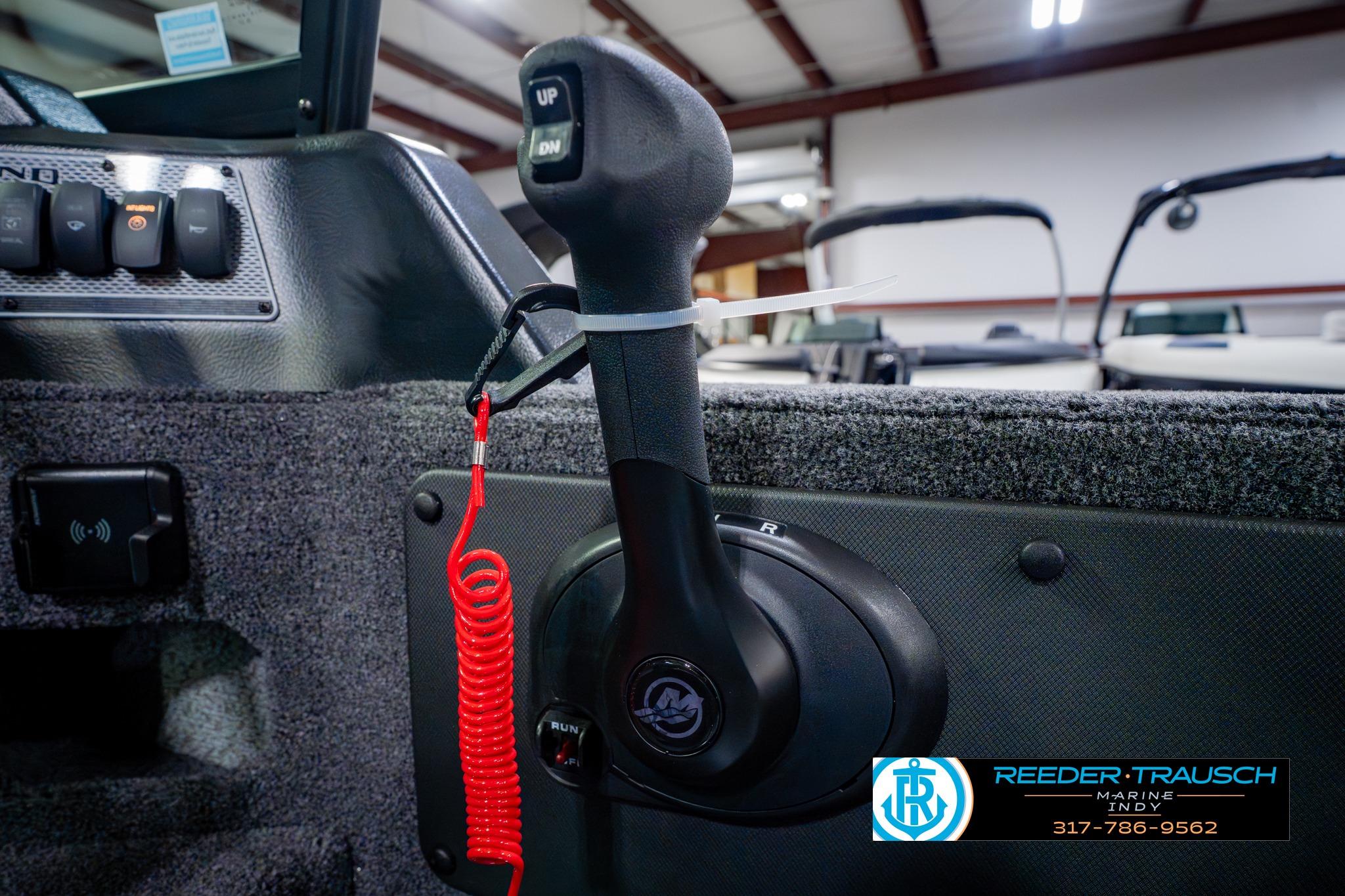2026 Lund 1875 Impact XS boat throttle control with red safety cord in showroom.