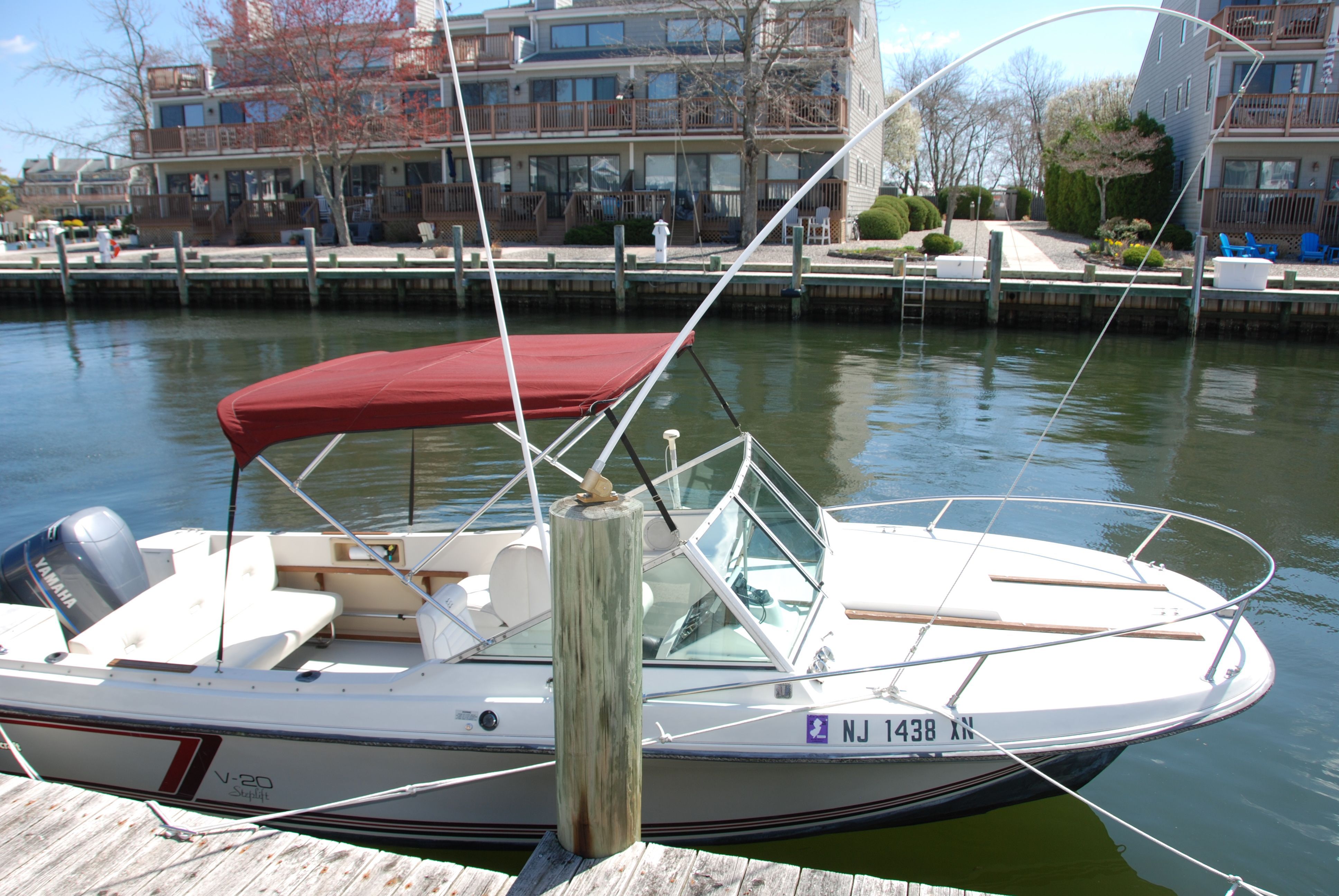 A 1987 Wellcraft V-20 Steplift docked, featuring a red canopy.