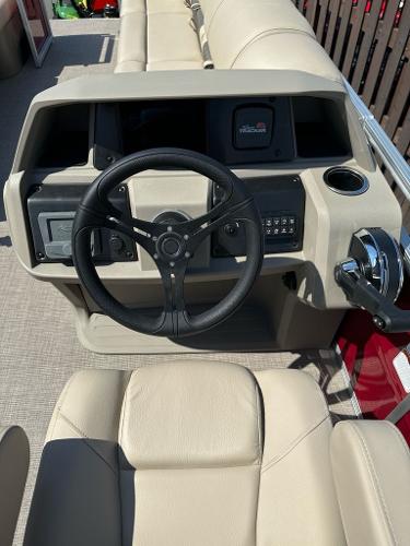 2025 Sun Tracker Party Barge 24 DLX steering console with beige seating and controls.